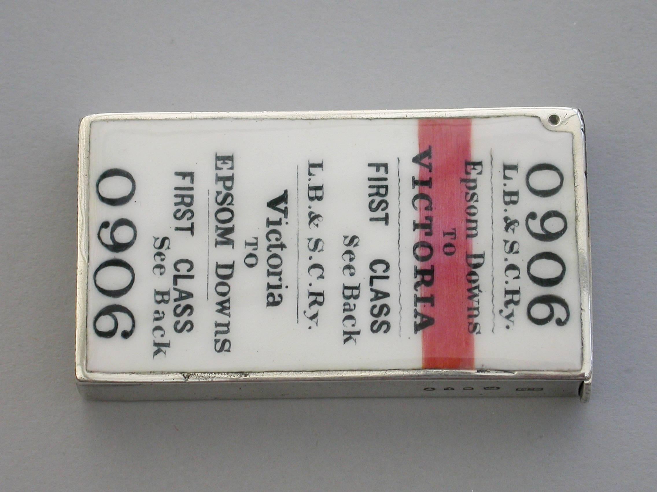 An extremely fine and rare Victorian silver and enamel novelty vesta case of rectangular form with flat hinged lid, the face enameled to represent a First Class London Brighton and South Coast Railway Train Ticket - Victoria to Epsom Downs. The