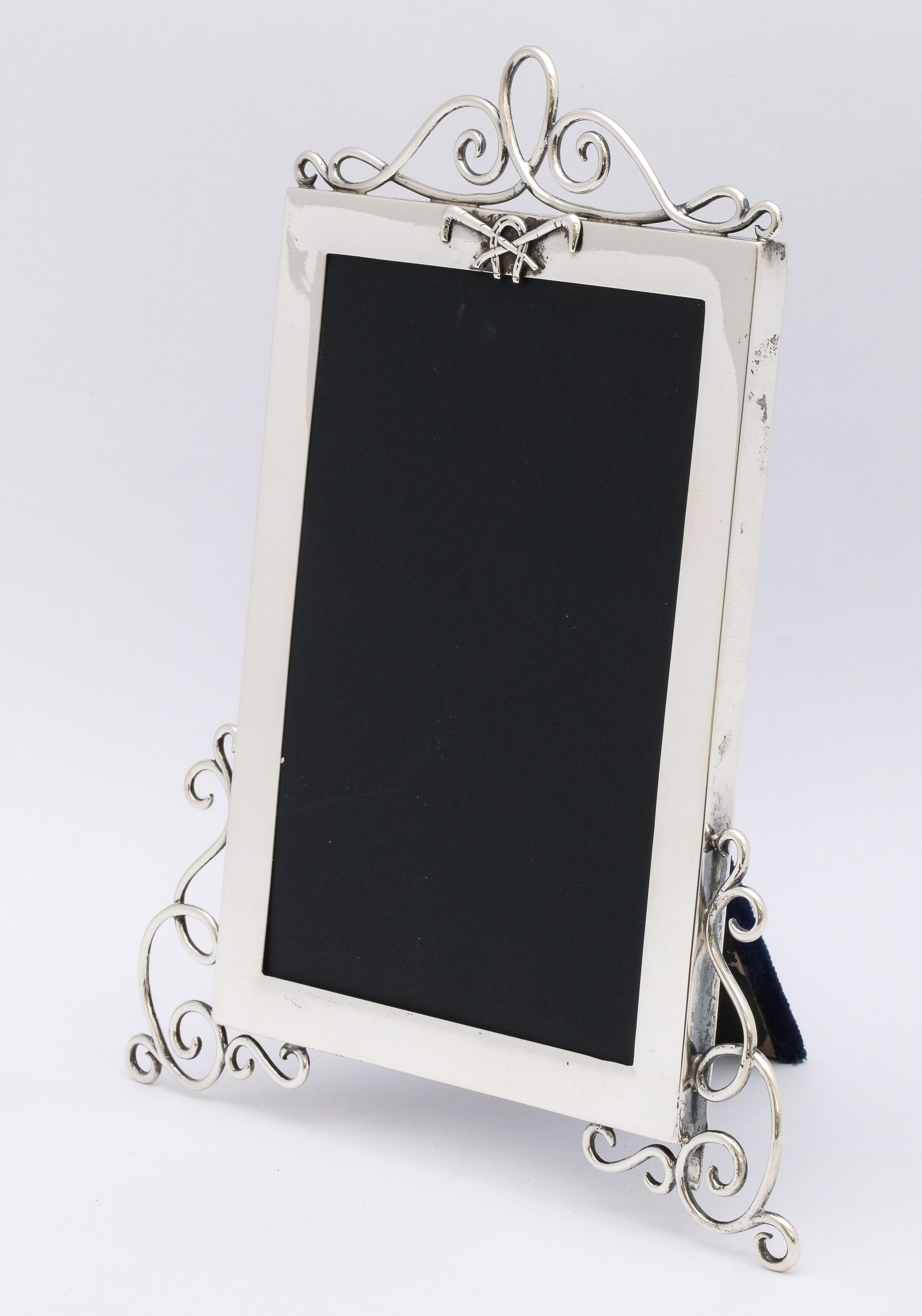 Rare, Victorian, sterling silver picture frame with equestrian motif, London, 1896, Goldsmiths and Silversmiths Co., Ltd - makers. A horseshoe and two crossed riding crops decorate the top of the frame. Frame has curled wire decoration at the top.