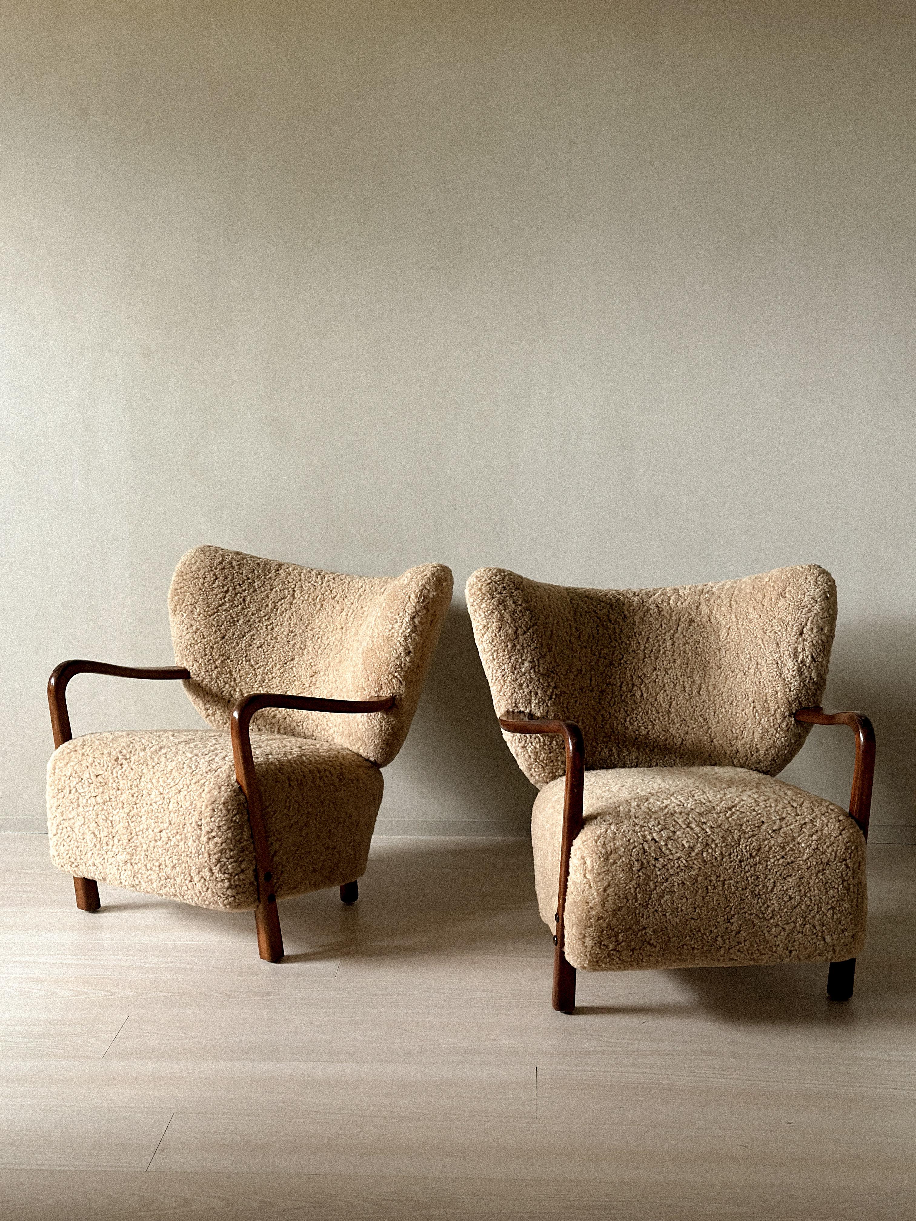 A rare pair of vintage beech and shearling chairs designed by Viggo Boesen (attributed) and produced by Hos Wulff in Denmark, circa 1930s. Newly renovated and reupholstered in premium beige sheepskin. Wear consistent with age and use. Marks,