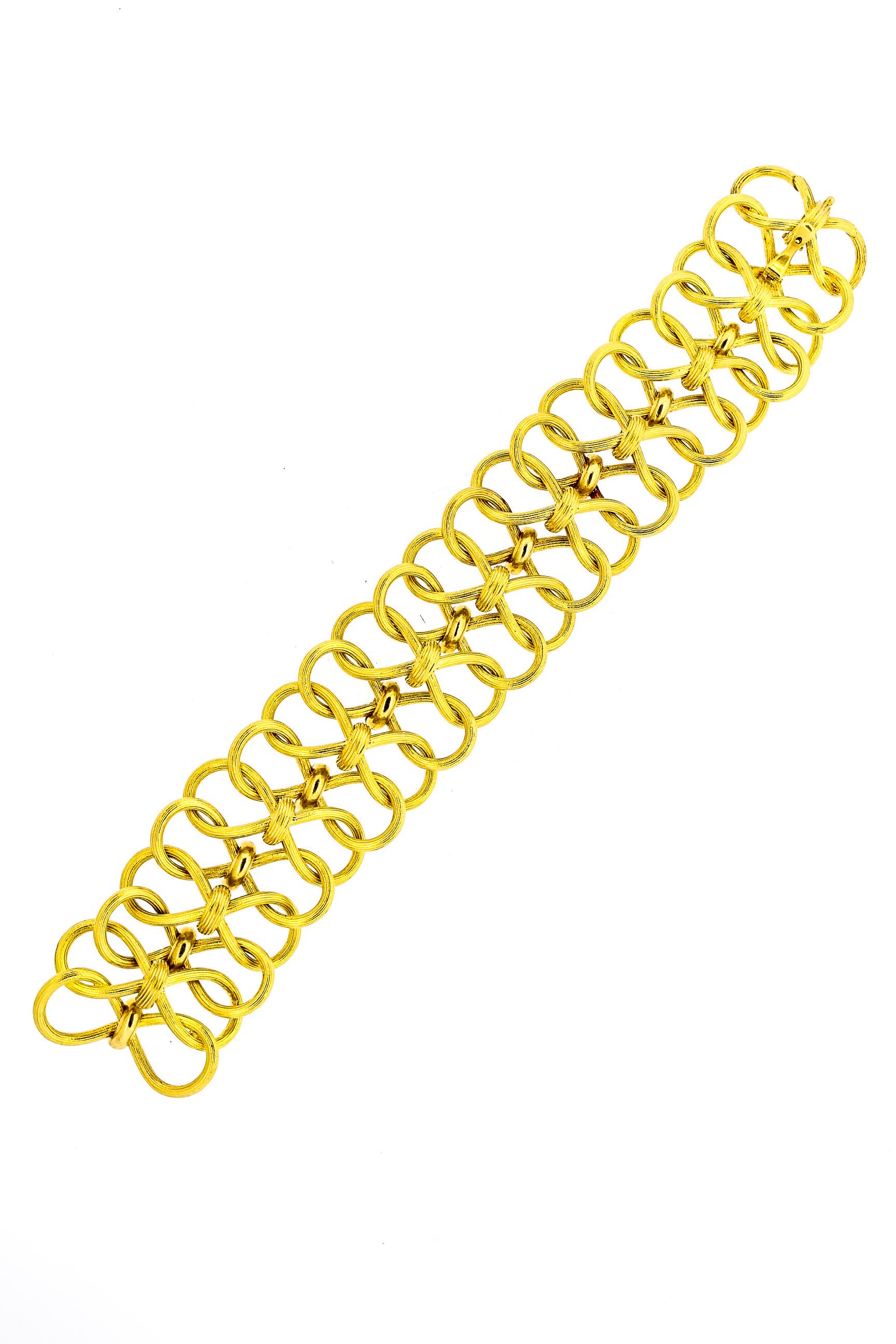 A unique rare 18k gold wide open link bracelet designed by Jean Schlumberger for Tiffany & Co. around the 1970s. This unusual link has textured gold loops that link in an under and over pattern. Schlumberger was an iconic designer for Tiffany & Co.