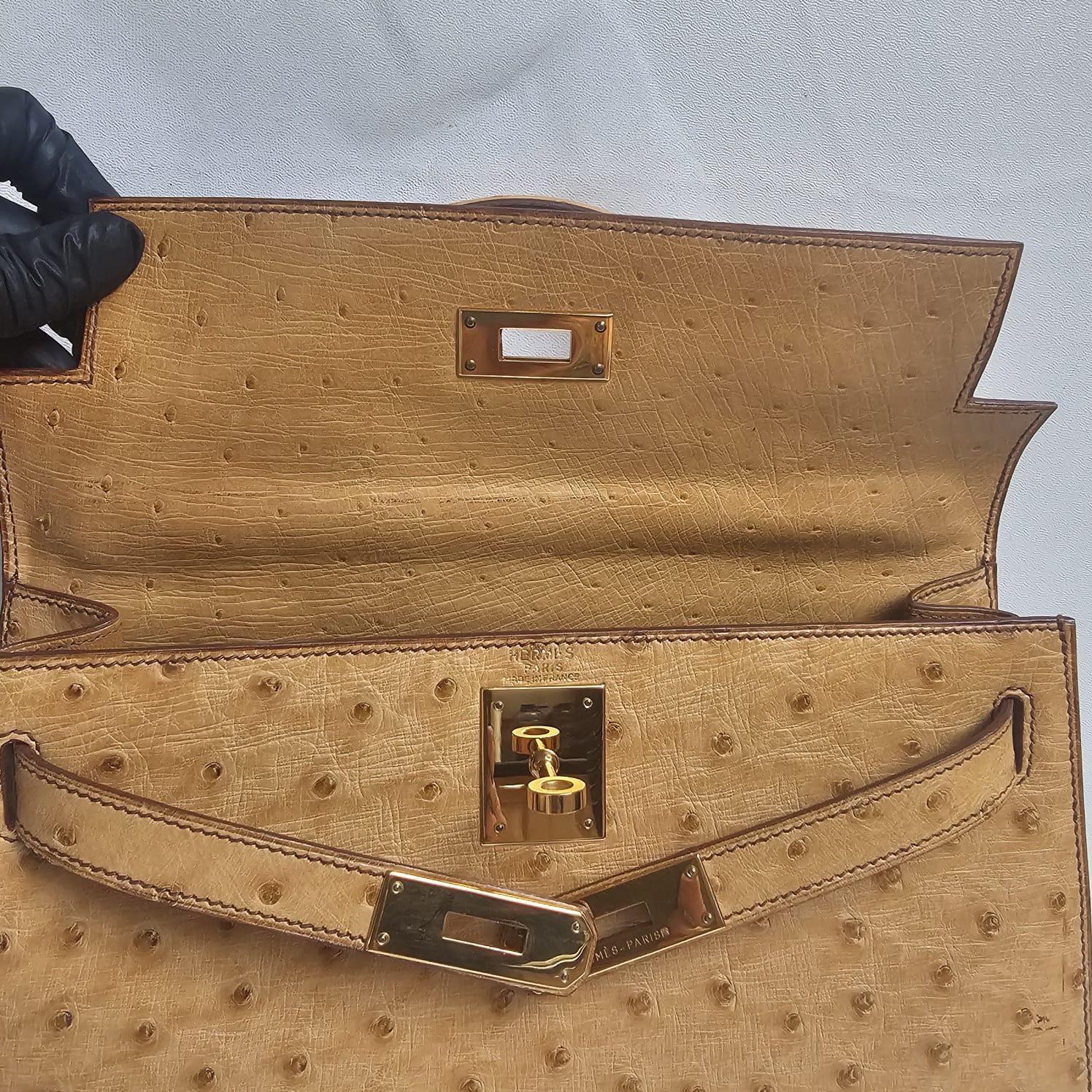 Très rare kelly 28 vintage en cuir d'autruche naturel avec quincaillerie dorée. Dans l'ensemble, il est encore en très bon état avec seulement de légers frottements sur les coins. Livré avec ses outils, sa sangle et son sac à poussière (sac à