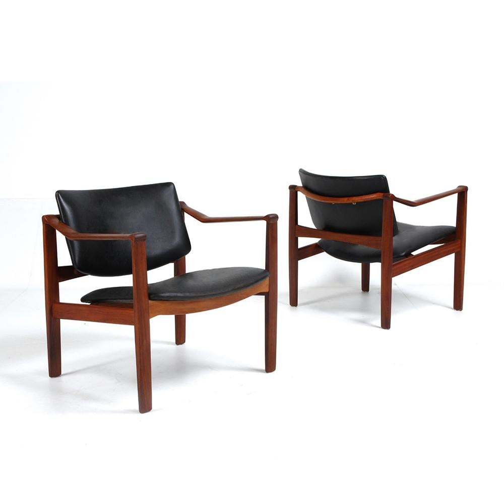 Pair of very rare armchairs, with an original look and a pure and aesthetic design. The beautiful wood structure gives them a singular elegance. Covered in high quality black leather. 
William Watting was an American furniture designer, who lived