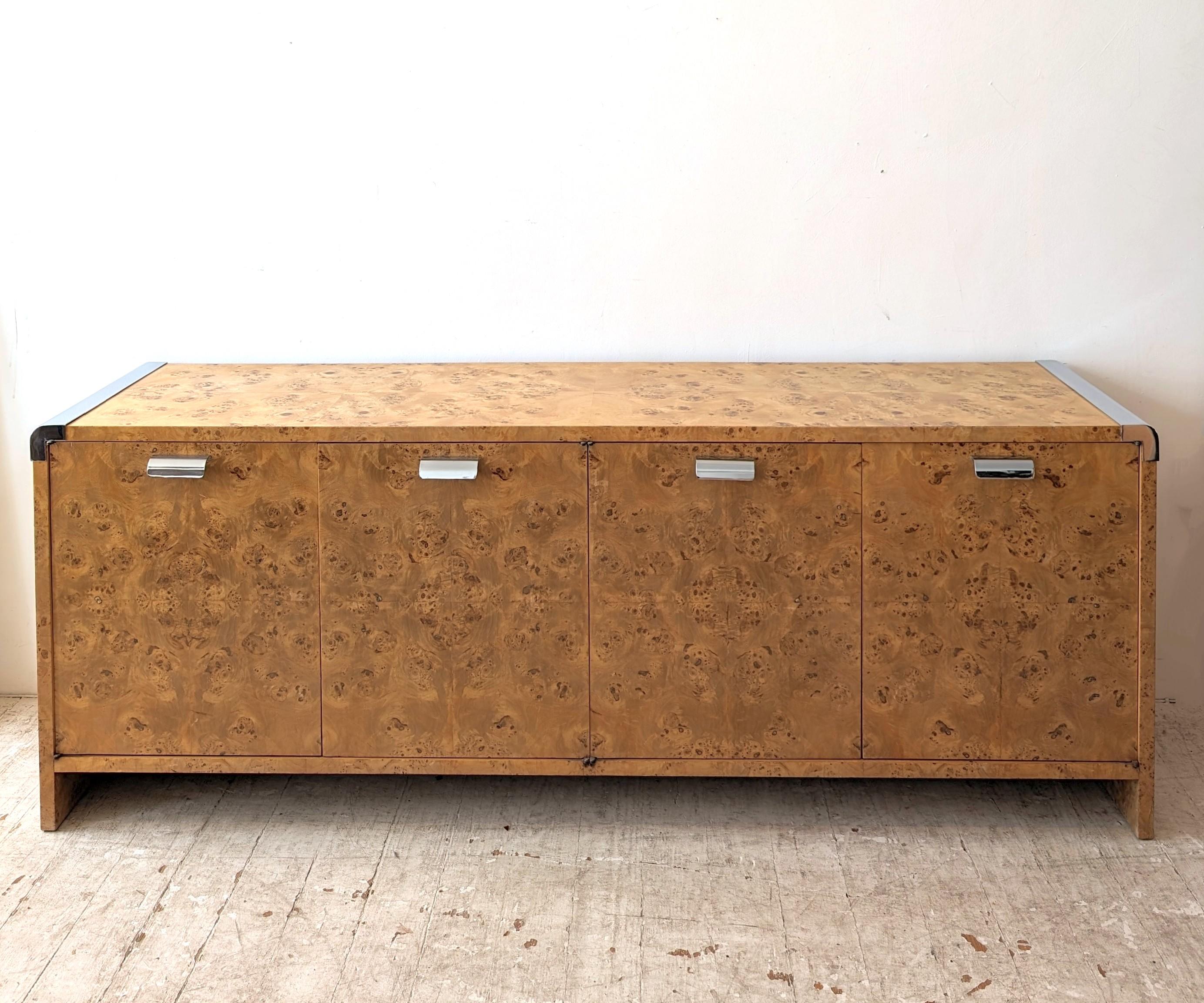 Rare burr olivewood and steel sideboard by Leon Rosen for Pace Collection, USA 1980s.
Curved chromed steel ends and handles. Beautifully figured bookmatched veneer top, front and ends. Cabinet doors open onto six large drawers.
No makers'