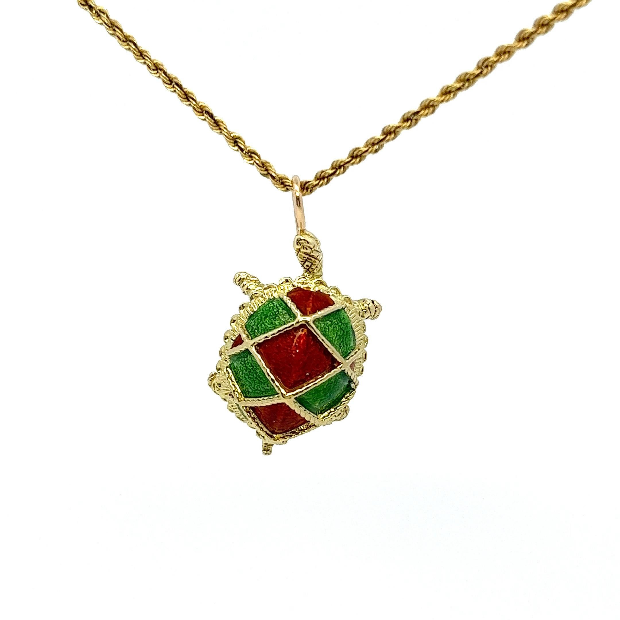 This Cartier pendant, dating back to the 1940s, is a notable representation of the brand's craftsmanship. Made of 18 karat yellow gold, it depicts a green and red enameled shell turtle. The turtle's body is distinct and intricate, with carved
