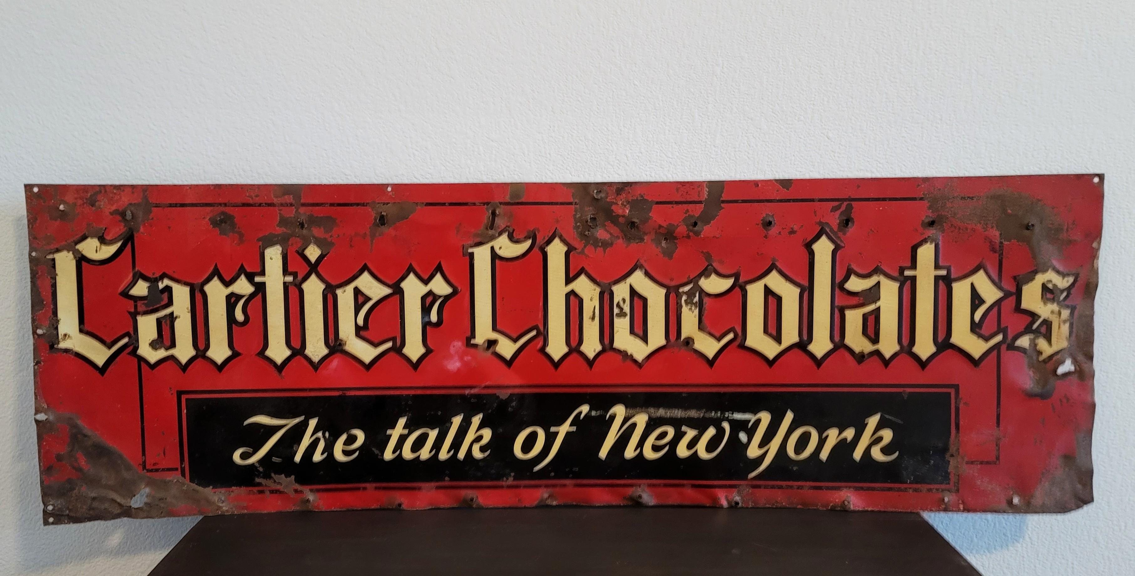 A scarce vintage Cartier Chocolates, The Talk of New York metal sign. 

Dating to the early/mid-20th century, the rare and important advertising sign once adorning the iconic Parisian luxury boutiques Fifth Avenue NYC Mansion flagship store.