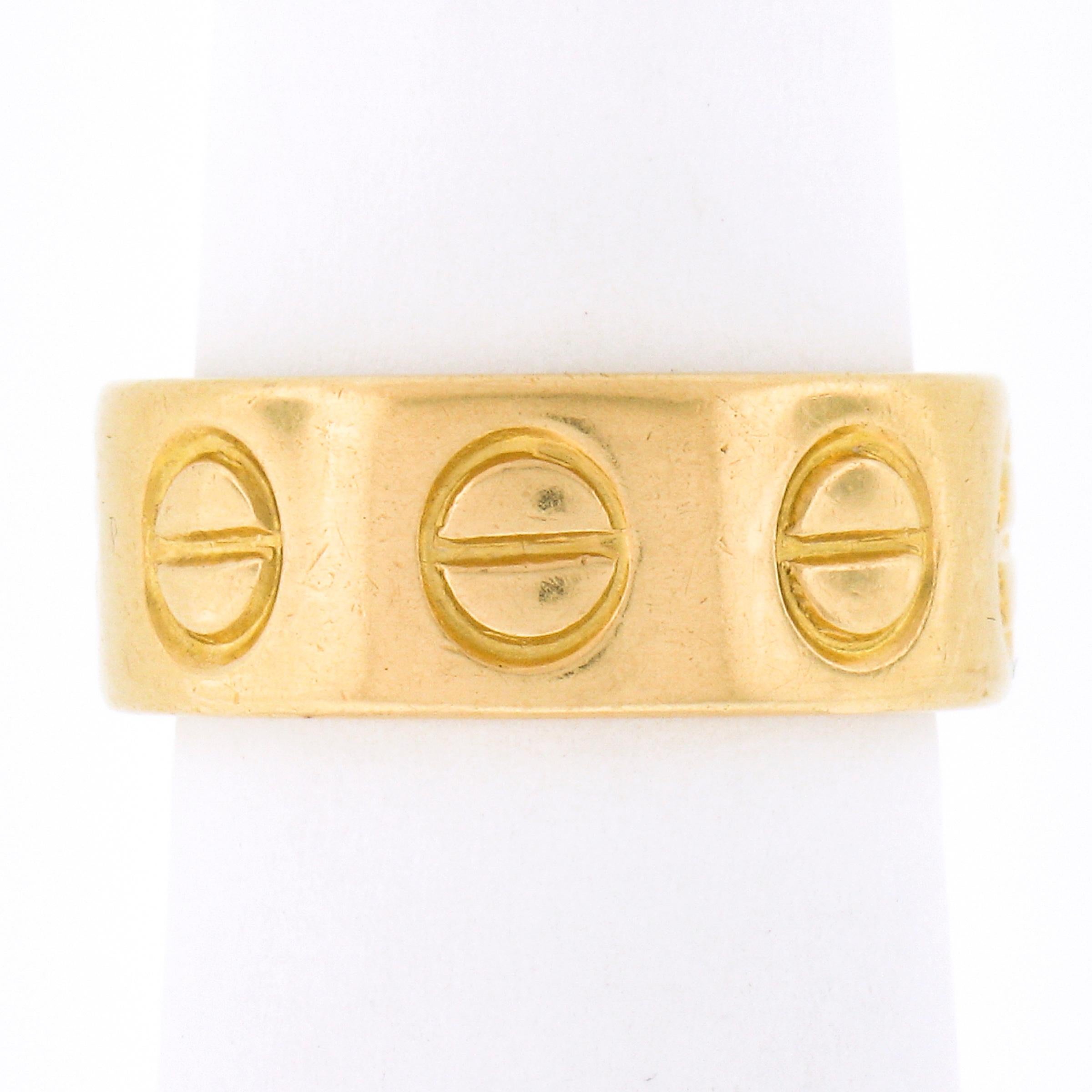 Up for sale is this rare vintage Cartier Love ring crafted in solid 18k yellow gold and signed with their old cursive signature style. This early design features a few more screw motifs than the new Love designed rings. The ring has its original