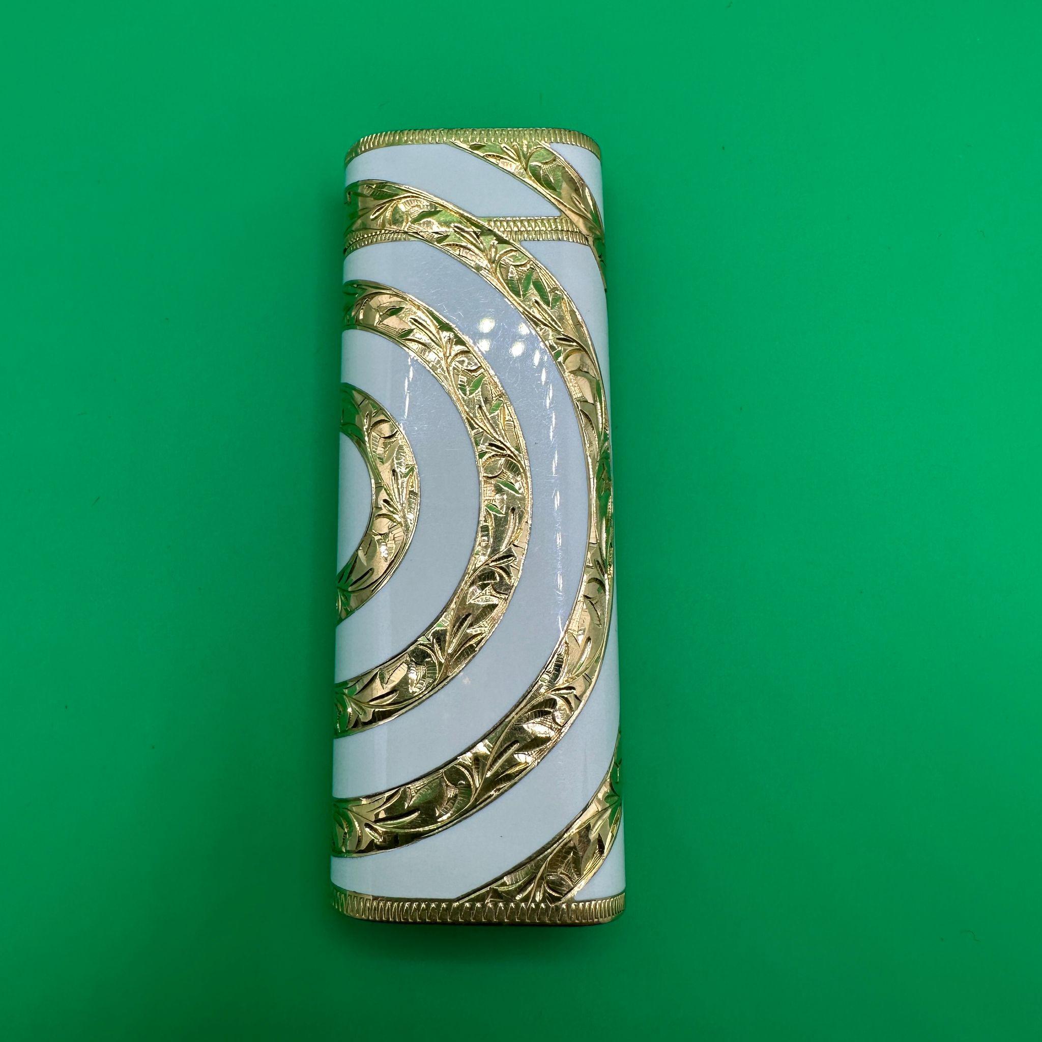 Rare Vintage Cartier RoyKing 18K Gold inlay and White Enamel 
Circa 70s
White Enamel
18 Gold inlay 
Baroque design 

Cartier “Royking” lighter.
Circe 1970
CARTIER  Roy King Rollagas, a Unique RARE example of a ROYKING designed Cartier Rollagas