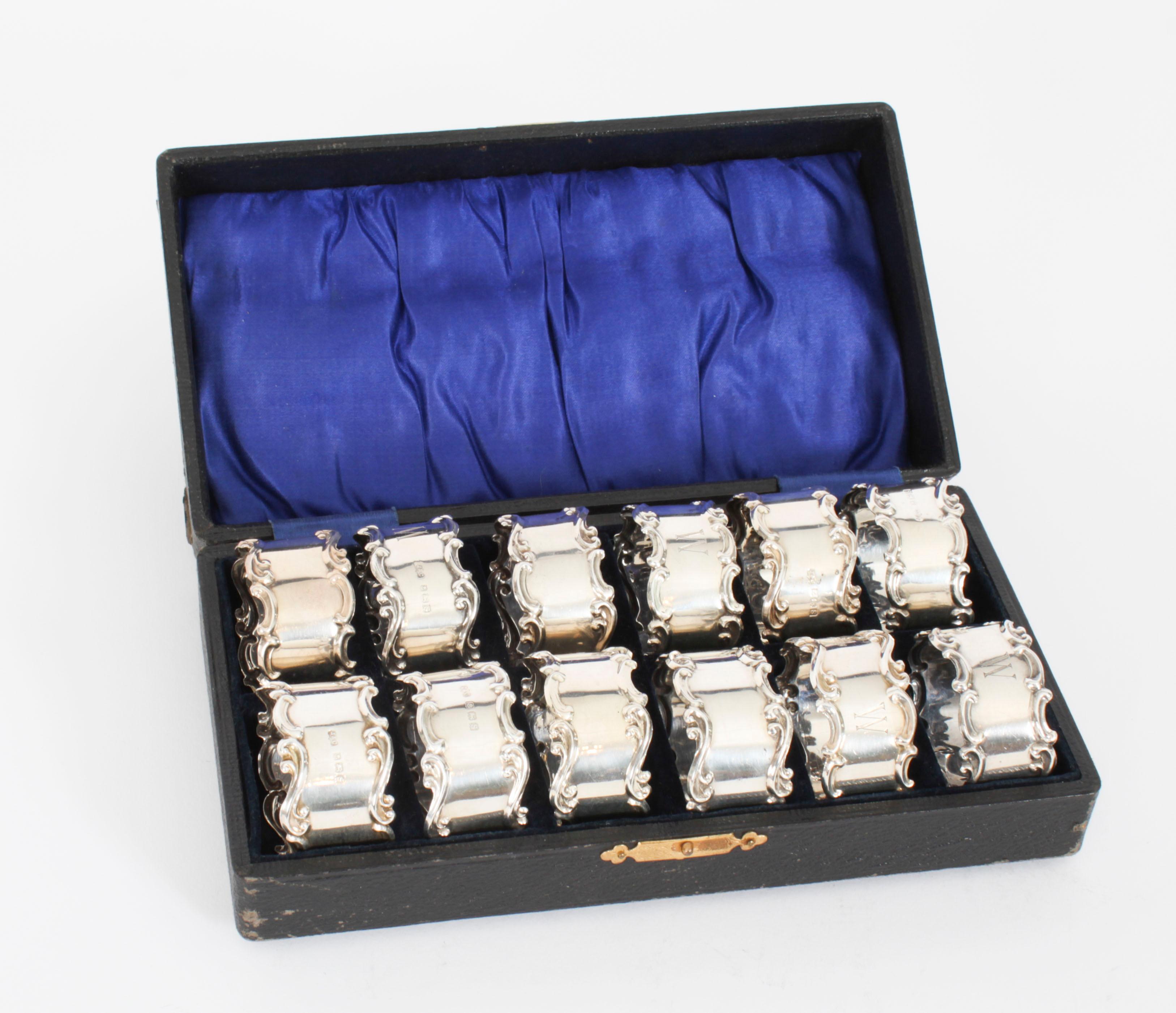 This is a beautiful and very rare cased set of twelve vintage sterling silver napkin rings, with superb decoration of scroll borders, each with engraved 'W', in the original leather and gilt case.

They bear the hallmarks of the silversmith Jones &