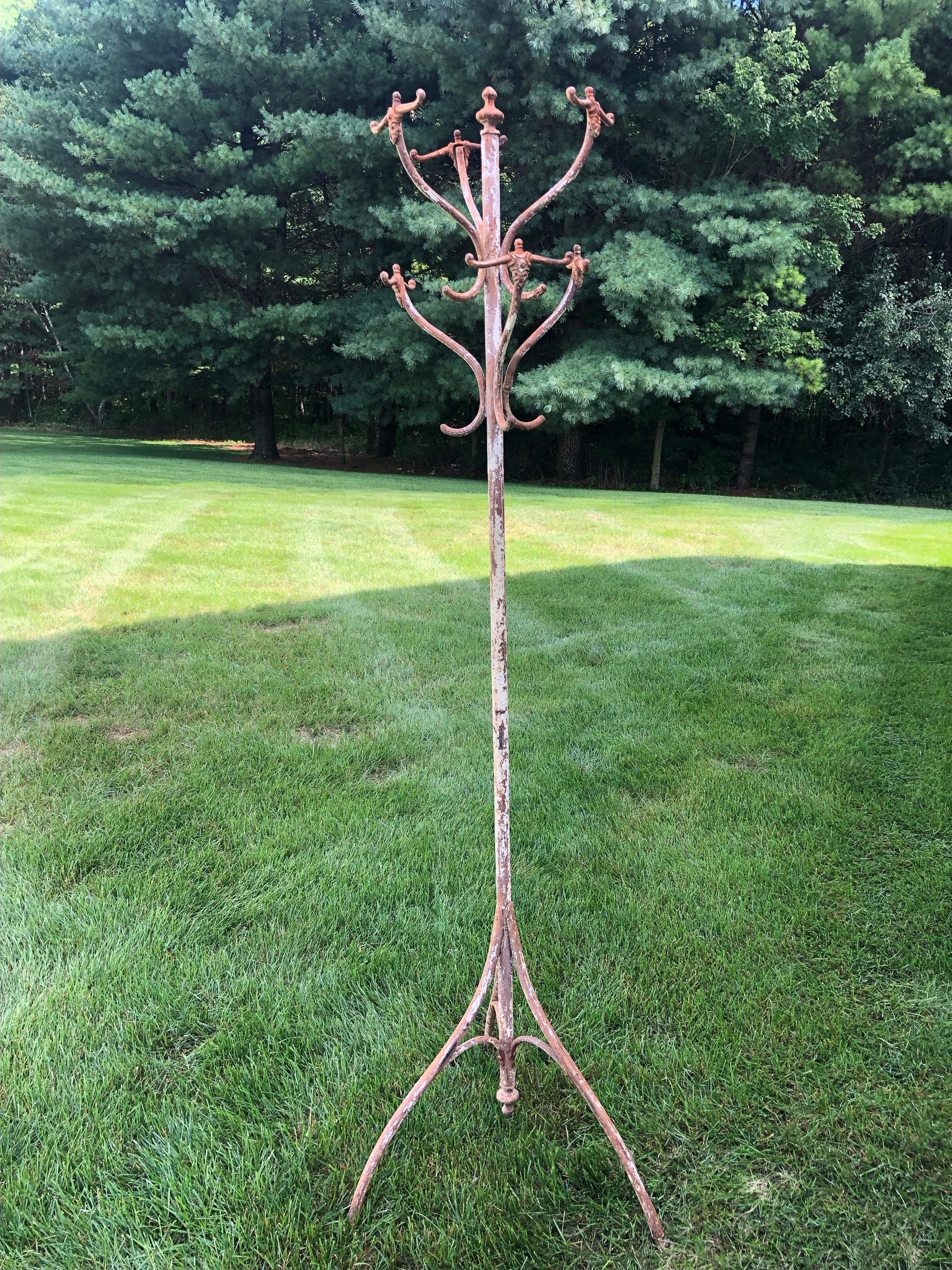 Rich in character and fully functional European cast iron coat rack having a marvelous aged patina with rust color and some areas of worn white paint.