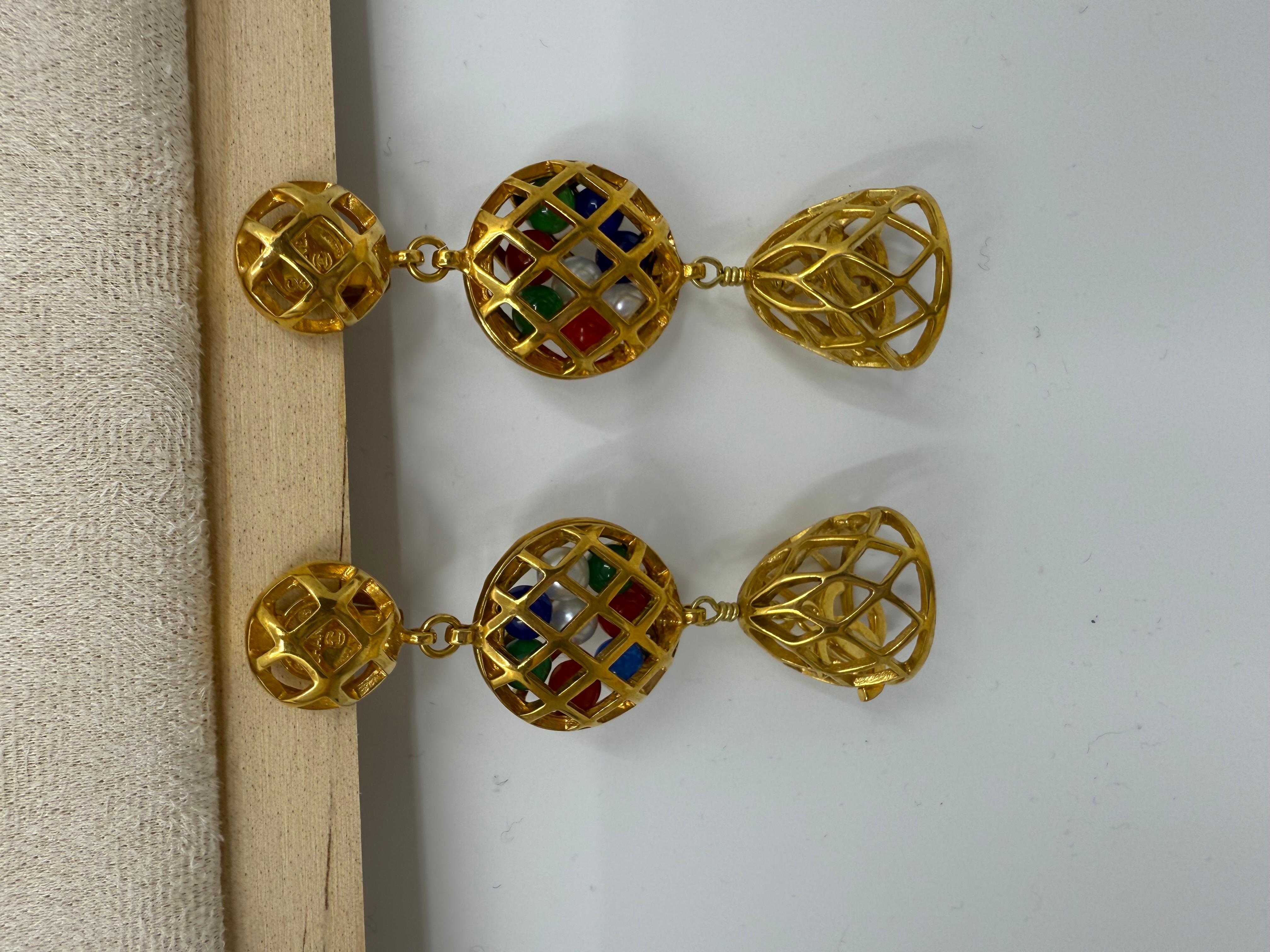 Questi orecchini a clip Chanel vintage, rari e stravaganti, risalgono alla fine degli anni '70 e all'inizio degli anni '80 e presentano un drammatico design a goccia in tre parti. Nella parte superiore, un bottone rotondo con motivo a griglia è