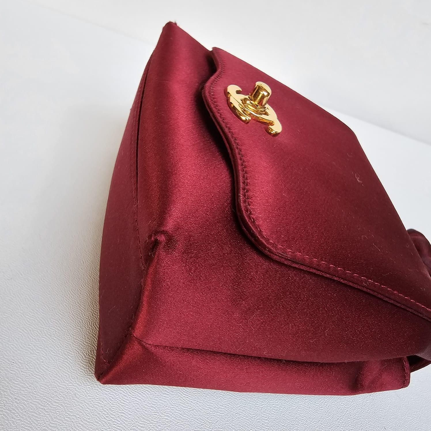 Very rare mini satin evening bag with wristlet in maroon with gold hardware. Beautiful and unique design in luxurious dark maroon color. Faint rubbings on the corners as shown on pictures but not to the point where its severe. Series #3. Comes with