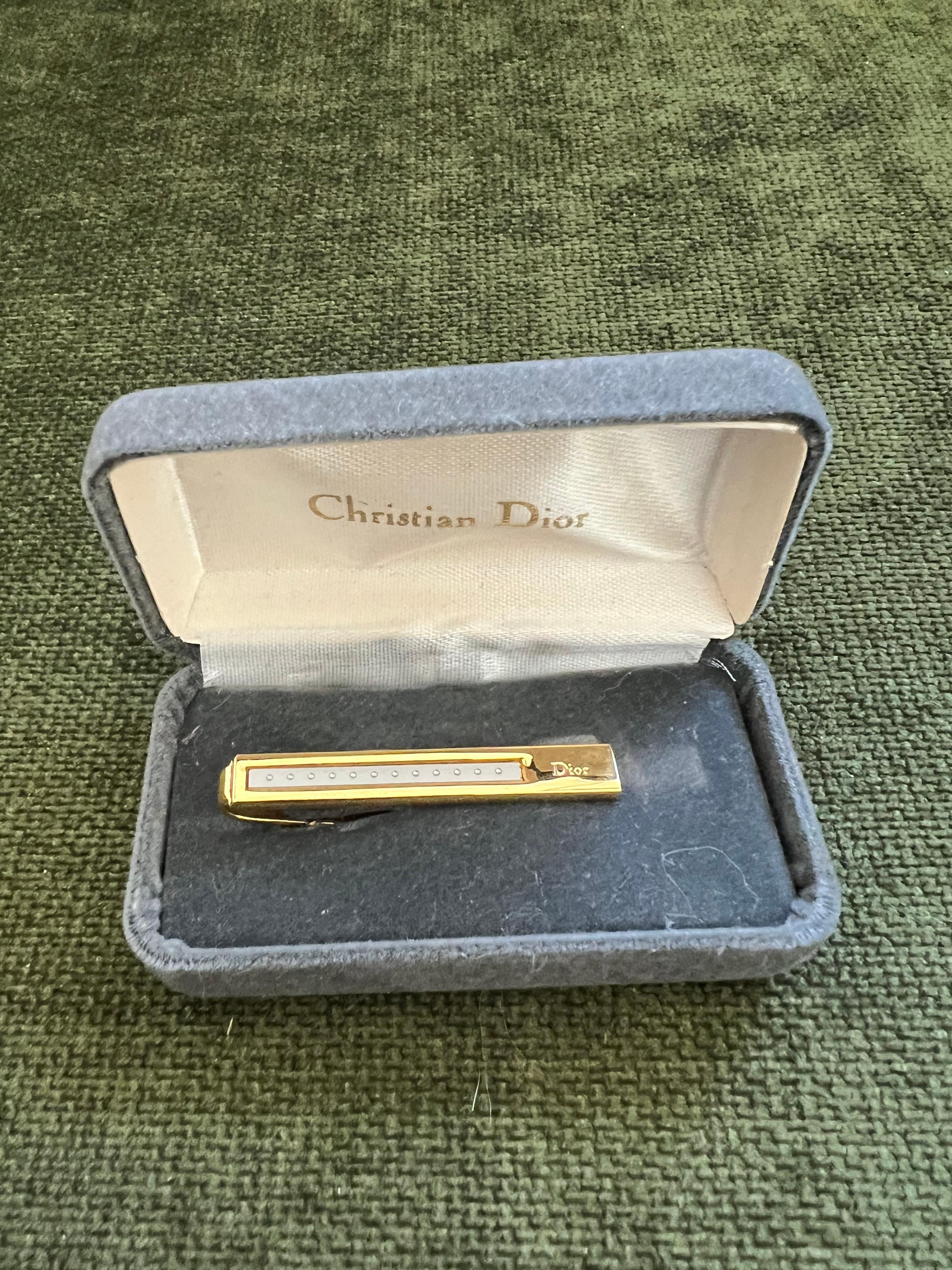 Fermacravatte d'oro Christian Dior d'epoca, circa 1980, con custodia originale 
Caratterizzata da logo Dior frontale, fondo testurizzato.

