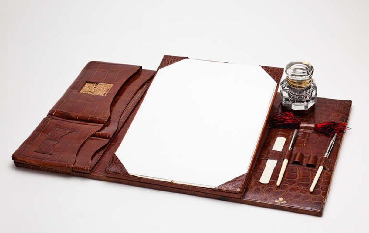 A rare and large vintage crocodile leather desk set of superb quality by Vickery, Regent Street, London, circa 1910-1915. The center panel can be slightly elevated by a spring loaded catch and it also has the original glass side inkwell.
We are