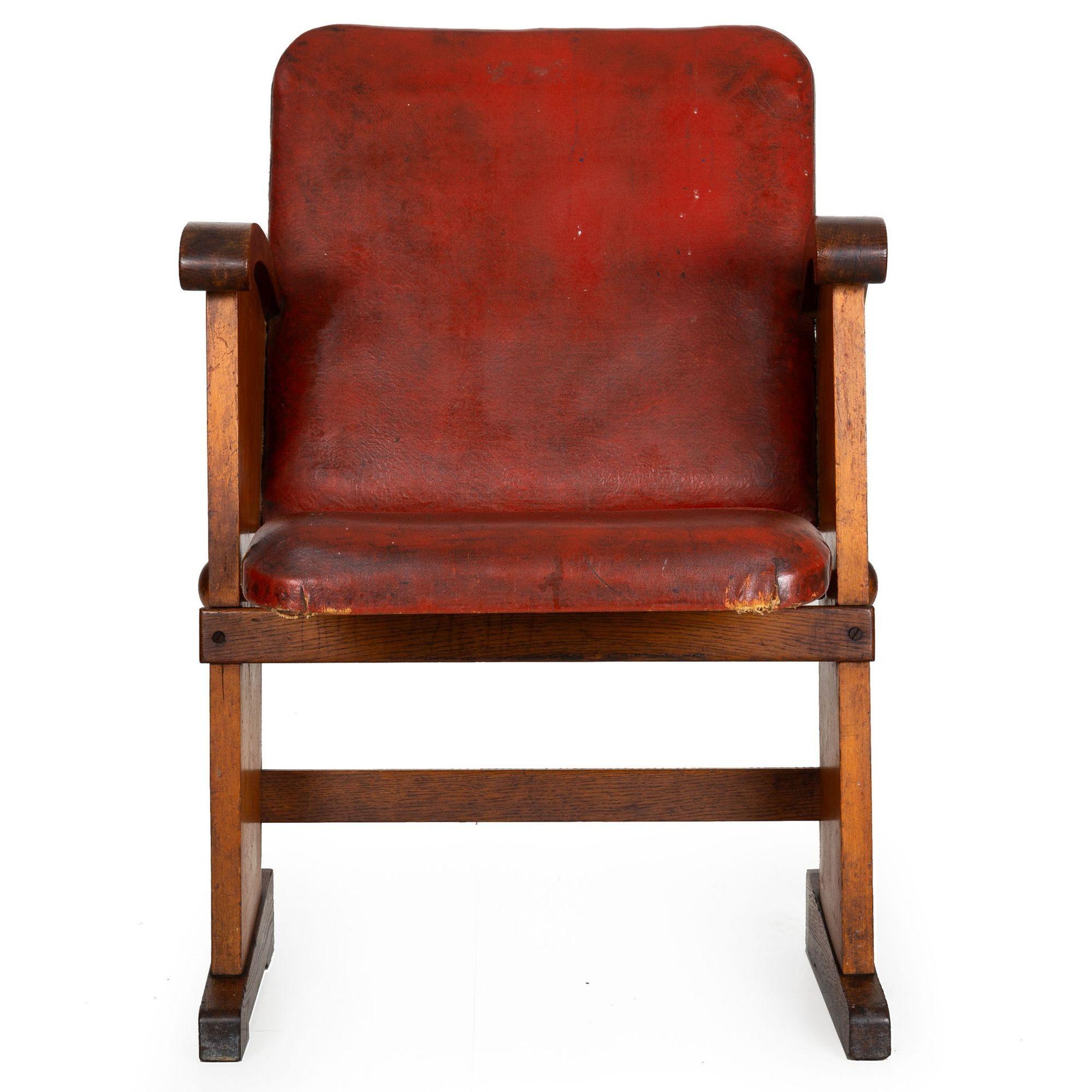 This rare and most compelling cinema chair absolutely pops with its rich and untouched historical surface throughout. The chair features a folding seat with original maroon-red faux-leather upholstery bordered on the seat-back by a thin element of