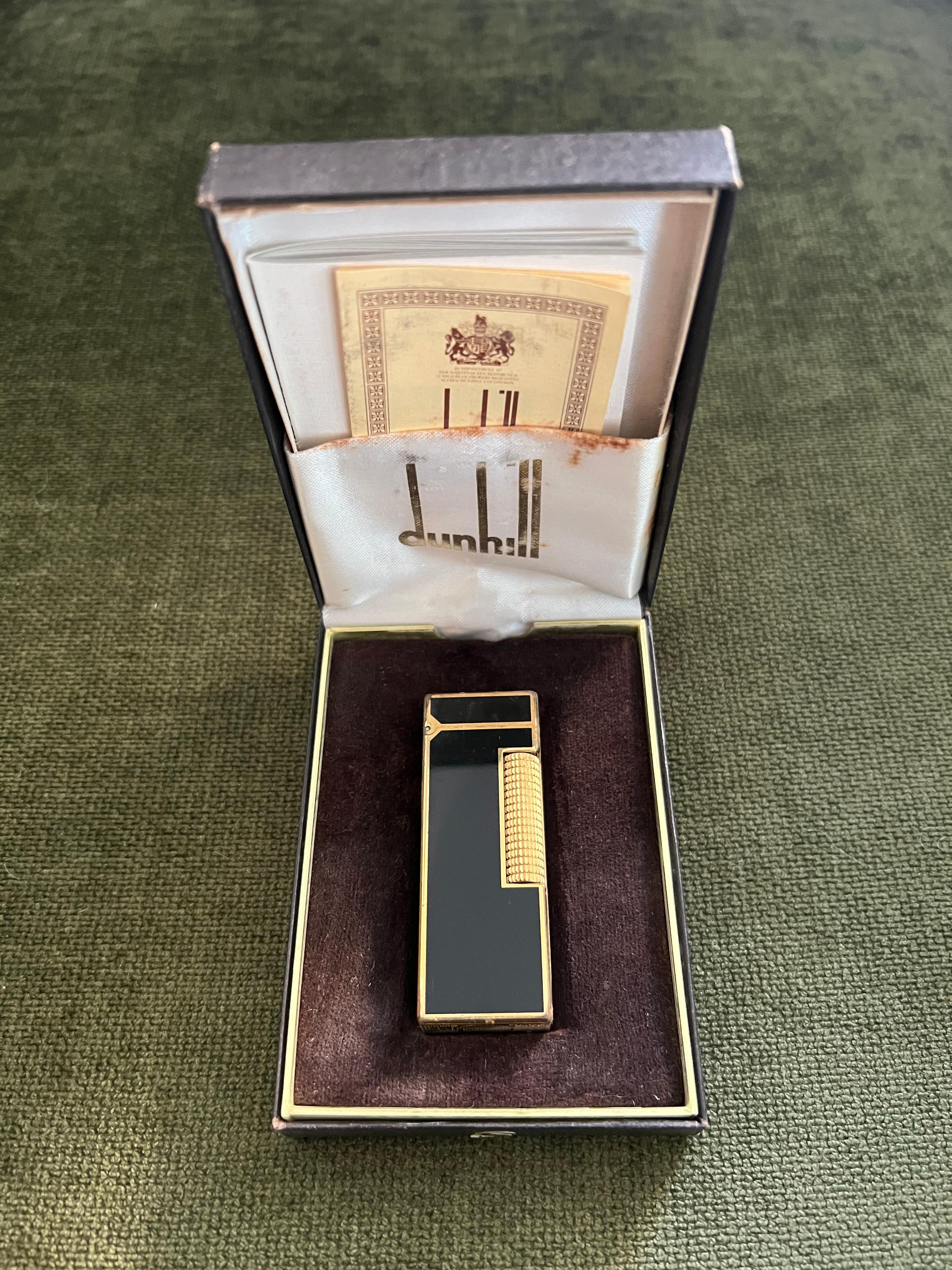 Rare Vintage Dunhill Vergoldet Schwarz Lack Feuerzeug Original Etui 
CIRCA 1970

Rare Vintage Dunhill vergoldet Schwarzlack Swiss Made Feuerzeug In neuwertigem Zustand.
Funktioniert perfekt. 
Ikonisches und wunderschön verarbeitetes Stück mit