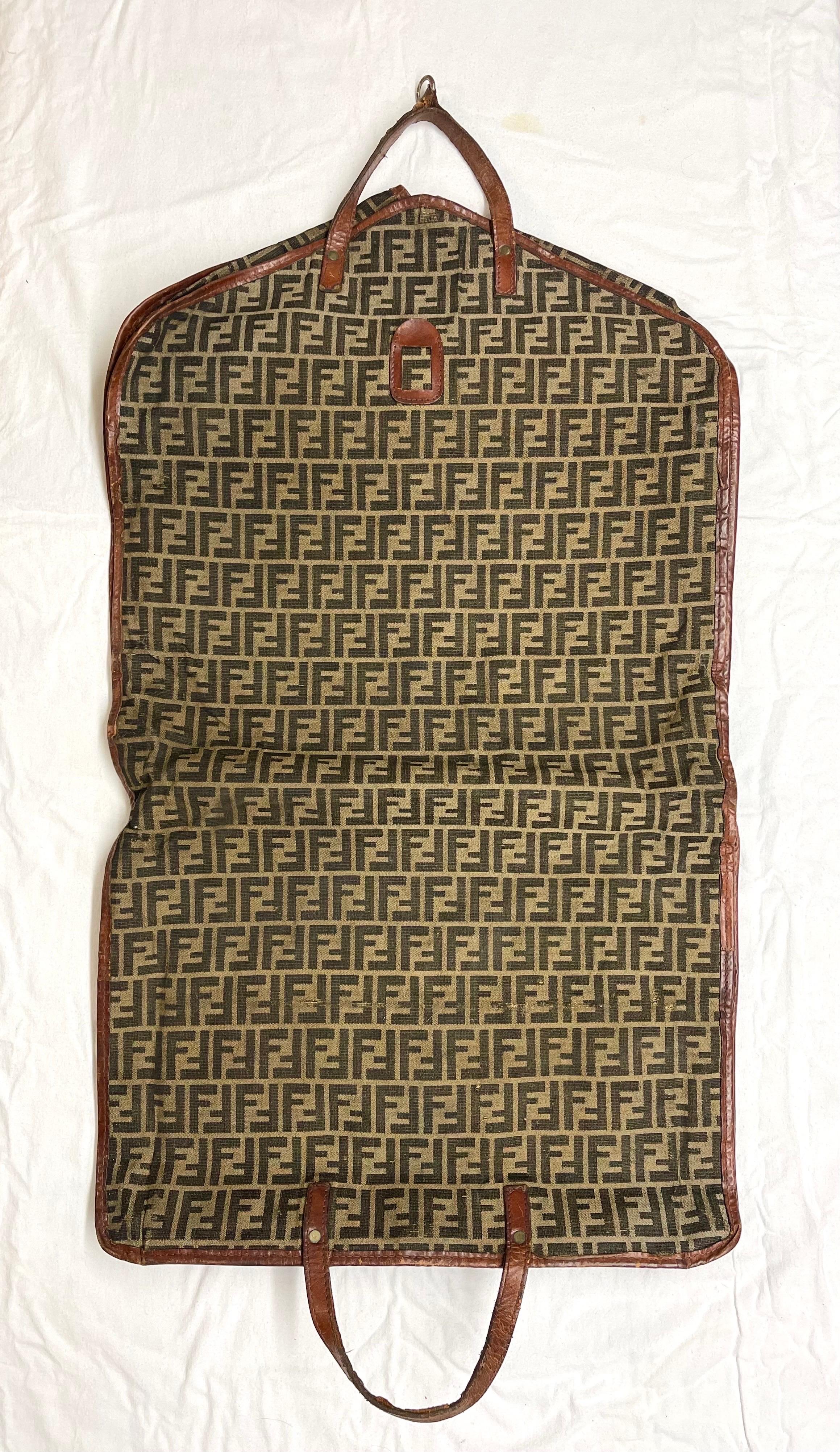 Rare Vintage Fendi Zucca Monogram Garment Travel Carrier. Klassische Zucca FF  Monogram-Muster auf braunem und tanfarbenem Canvas mit Lederbesatz. Perfekt für die modebewusste Weltreisende. 
Maße: ca. 44