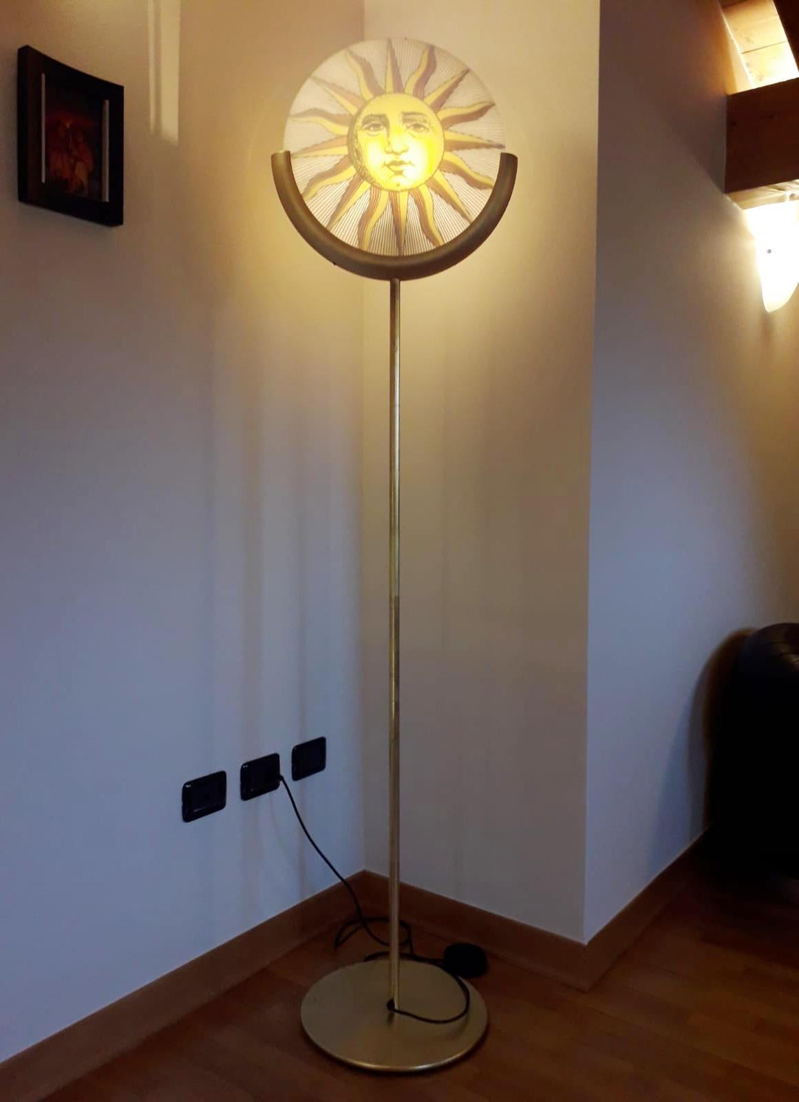 Vintage Italian floor lamp in gilt wood and metal with reverse painted depictions of the Sun and Moon, designed by Piero Fornasetti, manufactured by Antonangelli Illuminazione in Milan Italy in the 1980s
1 light / E26 or E27 type / max 60W