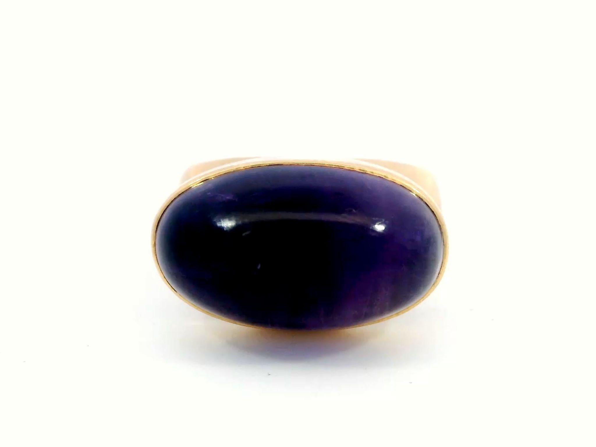 Vintage Tuk Fischer for Georg Jensen 18k Amethyst Cabochon Ring

The Vintage Tuk Fischer for Georg Jensen Amethyst Cabochon Ring is a bold piece that effortlessly captures attention. Made in smooth 18k yellow gold, this ring showcases a deep purple