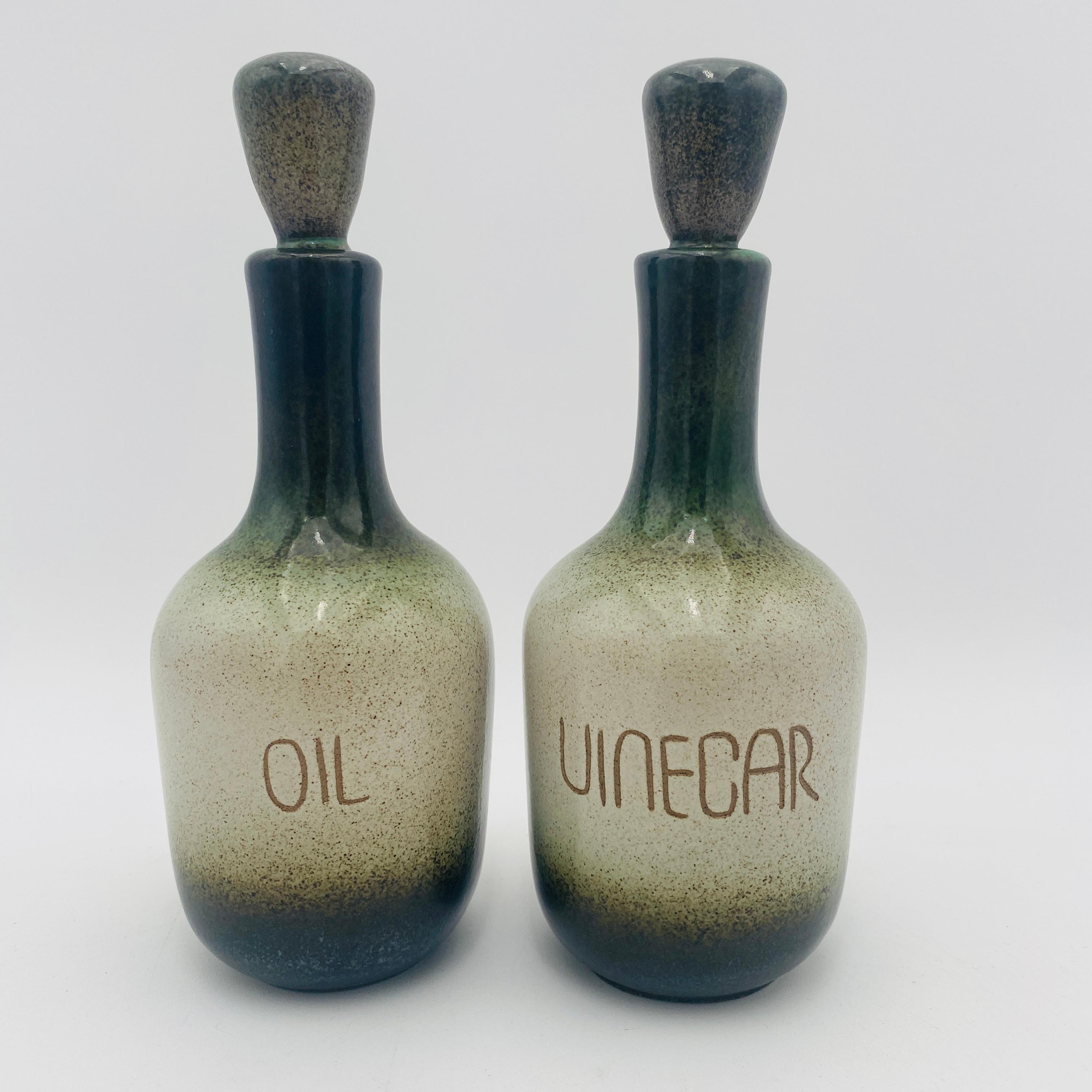 Dies ist ein seltenes Heath Ceramics Öl und Essig Set. Beide Flaschen haben ihre Originalverschlüsse und sind mit dem eingeschnittenen Heath-Logo versehen. Die Flaschen sind mit den Stöpseln 8