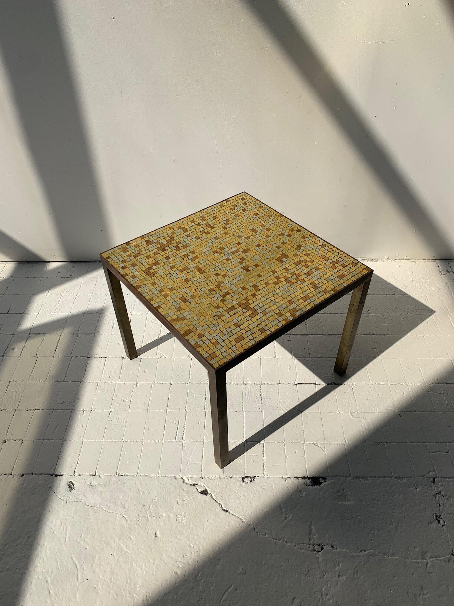 Vintage Hollywood Regency Brass Frame and Glass Metallic Mosaic Tile Tables, Circa 1960s. Beautiful geometric foiled glass mosaic tiles in tones of bronze, silver and gold. Expertly crafted brass frame.

**One table available.

Specs: 18 1/8” L  18