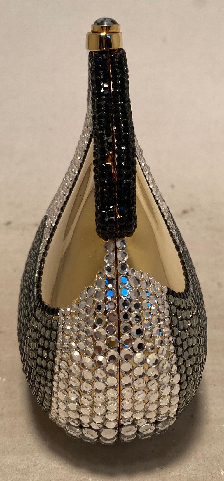 Rare Vintage Judith Leiber Crystal Chantelaine Minaudiere in excellent condition. Gold coin purse shape body with black crystals along the top edge and silver, grey and black along the front, back and bottom. Top button closure opens to a gold