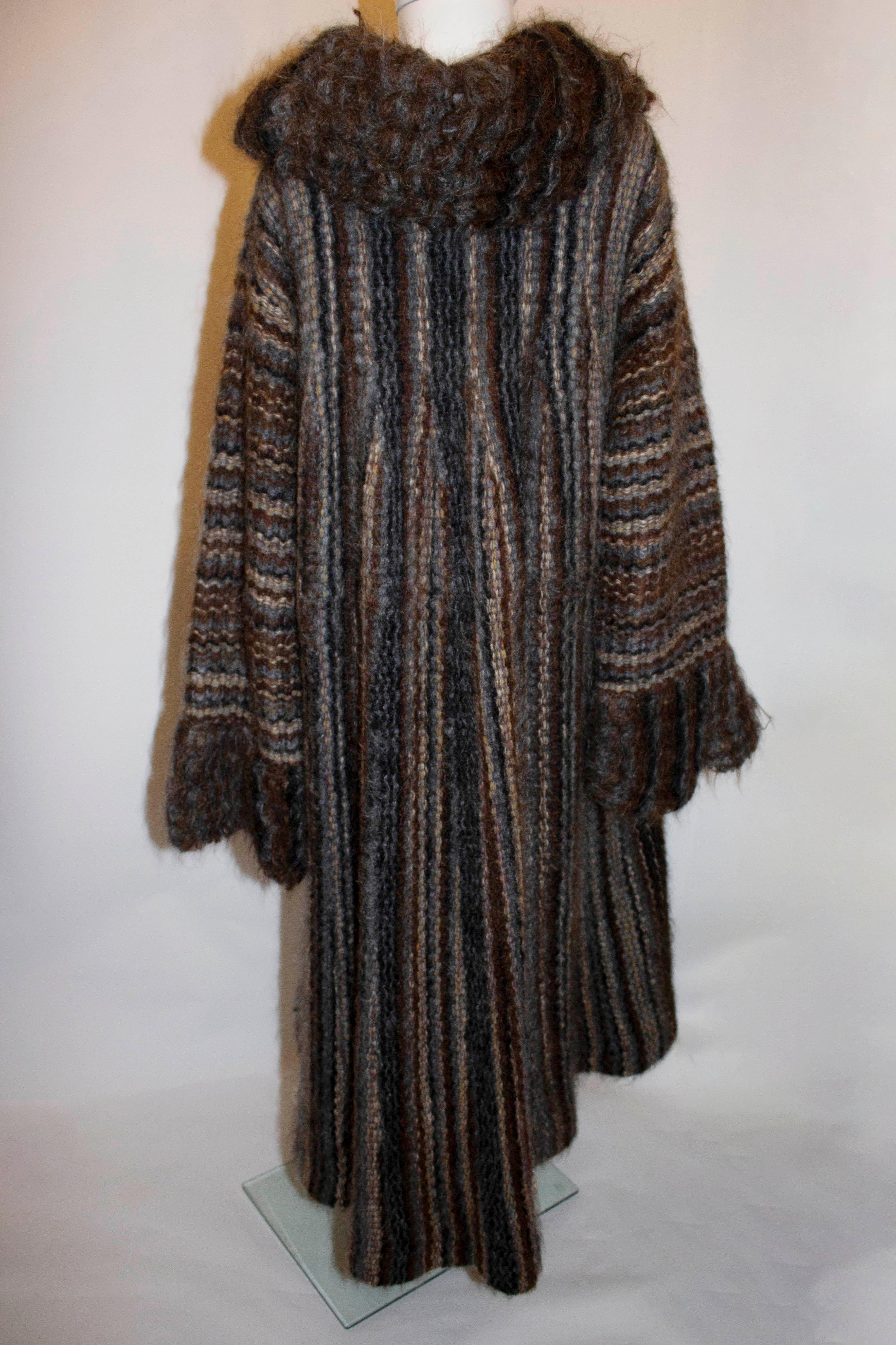 A vintage knitted coat by celebrated knitwear designer Kay Cosserat.  The coat is in a wool, mohair mix in various shades of brown, black and cream. The coat is lined and has a two button fastening with wide collar and pocket on either side.  It has