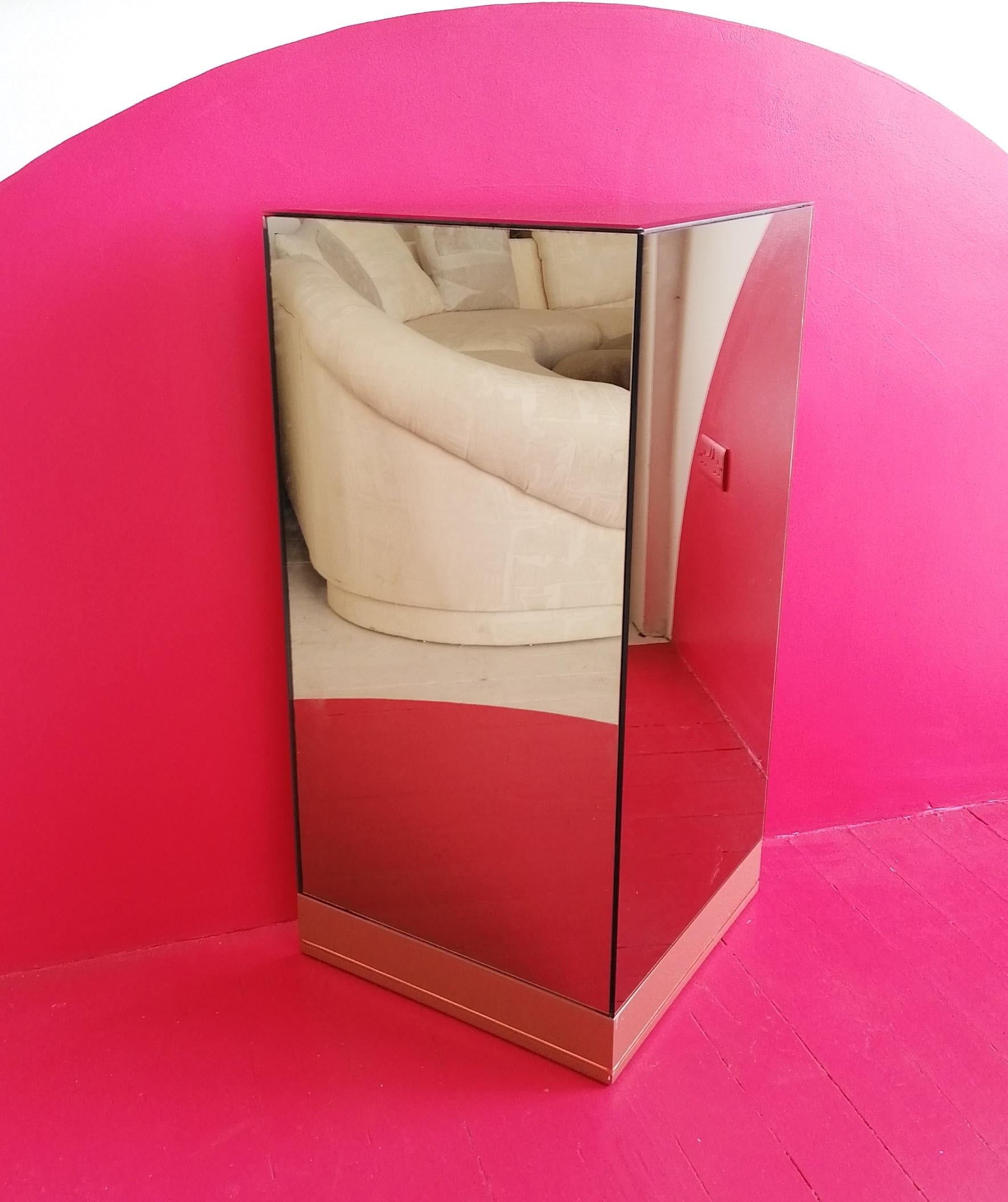 Rare large triangular mirrored plinth by Roger Rougier, Canada, 1970s. Mirrored on all sides, with the top in bevelled mirror glass. Pink lacquer base.