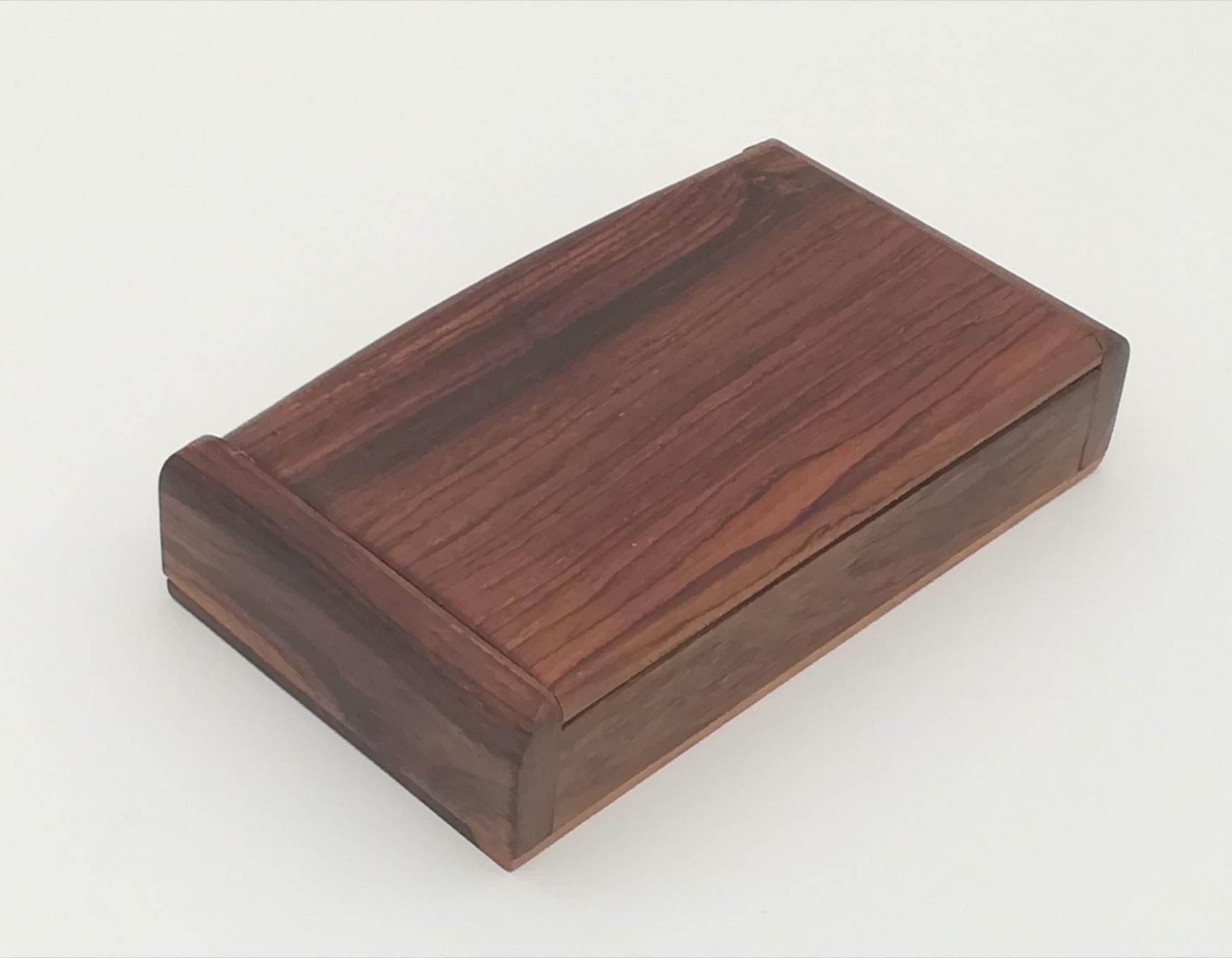 This beautiful and heavy cigar box, conceived by renowned Austrian designer Carl Auböck, appears in an elegant and noble manner on the table it occupies. The quality of the object shows very nice details in the wood and a fine sapwood accent. A fine