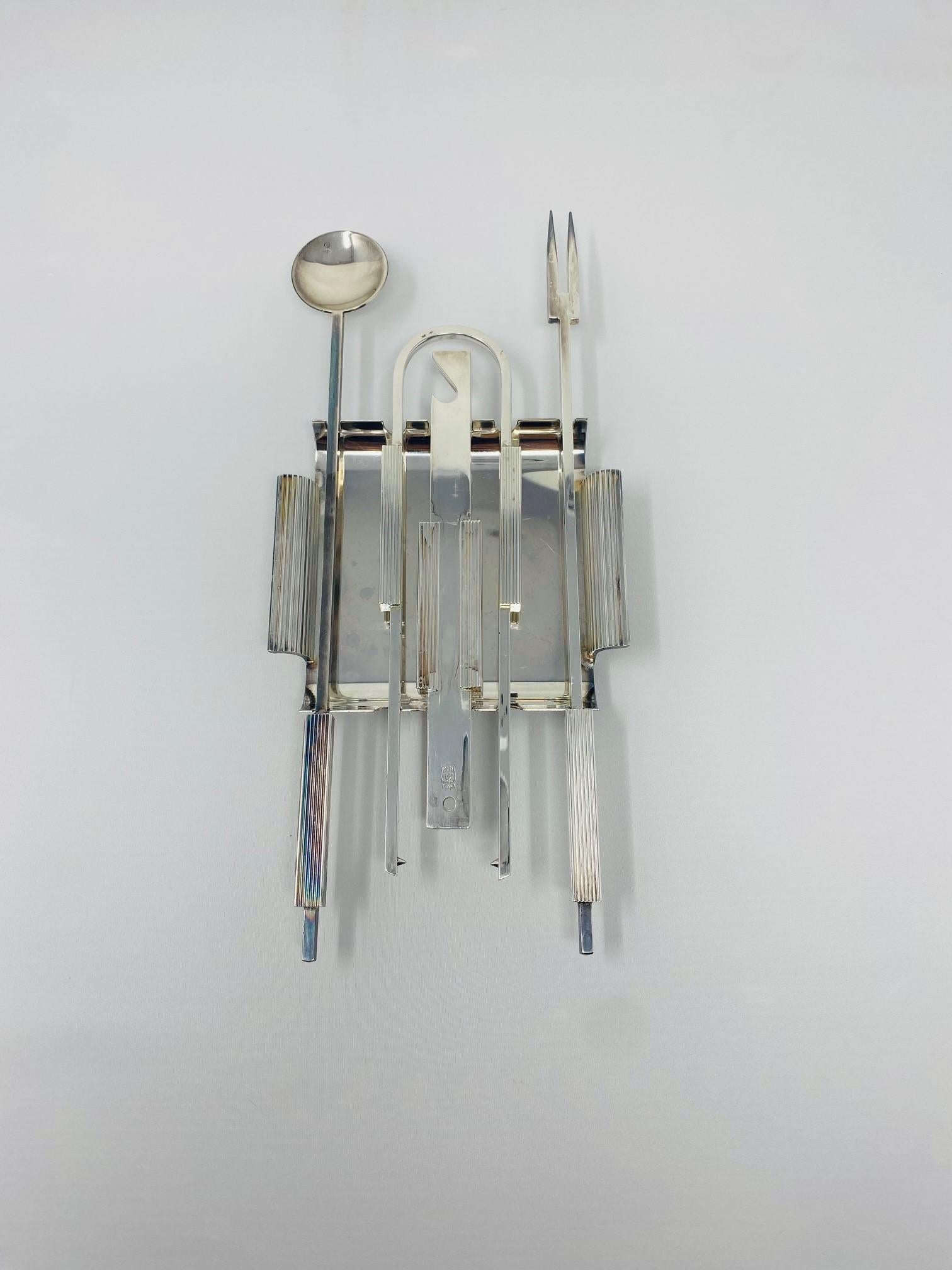 Very unique and rare Gio Ponti style bar tool set. This wonderful original bar utensils set in silverplate is simply breath taking in design. The set includes bottle opener, mixing spoon, ice tong and long cocktail fork. The sleek and classic