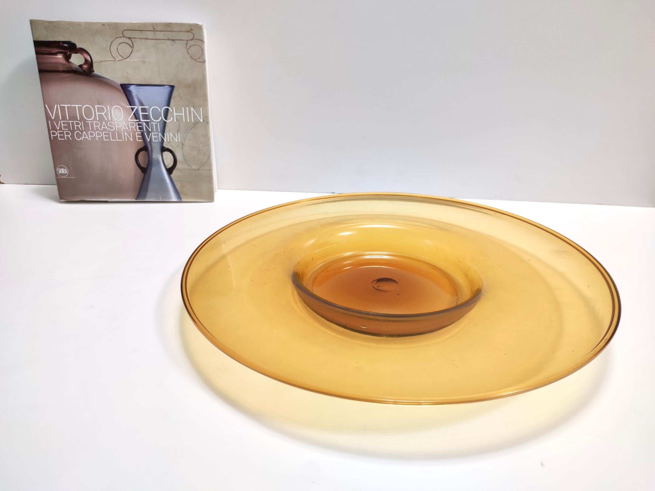Made in Italy, 1921 - 1922. 
This stunning trinket bowl / vide-poche is made in orange hand-blown Murano glass.
It was presented at Salon D'Automne in Paris in 1922 and at the Biennale of Monza in 1923.
The color yellowish orange makes it quite rare