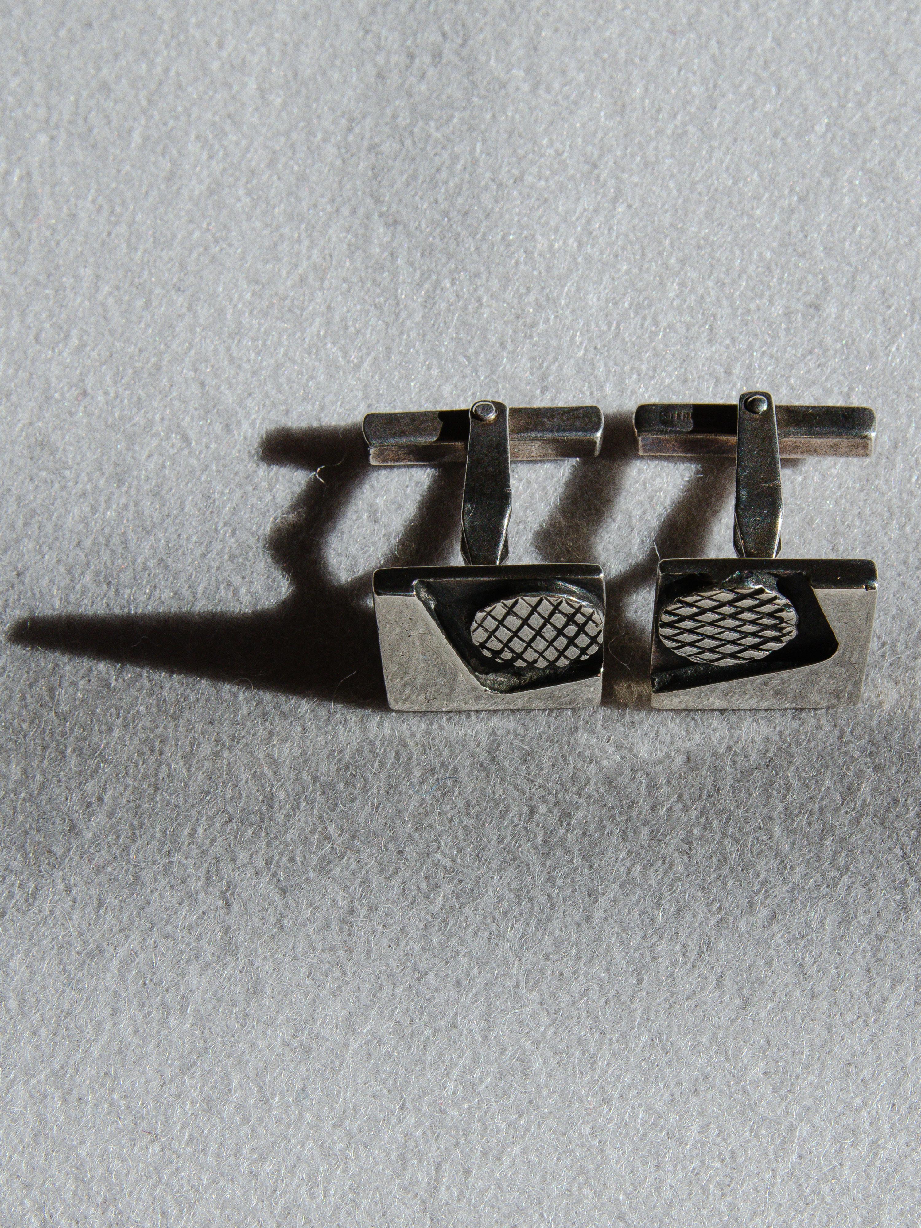 Rare paire de boutons de manchette en argent sterling conçus par Margaret DePatta (1903-1964), l'une des bijoutières modernistes les plus influentes et les plus collectionnées du milieu du XXe siècle. Son adhésion au design Bauhaus et ses