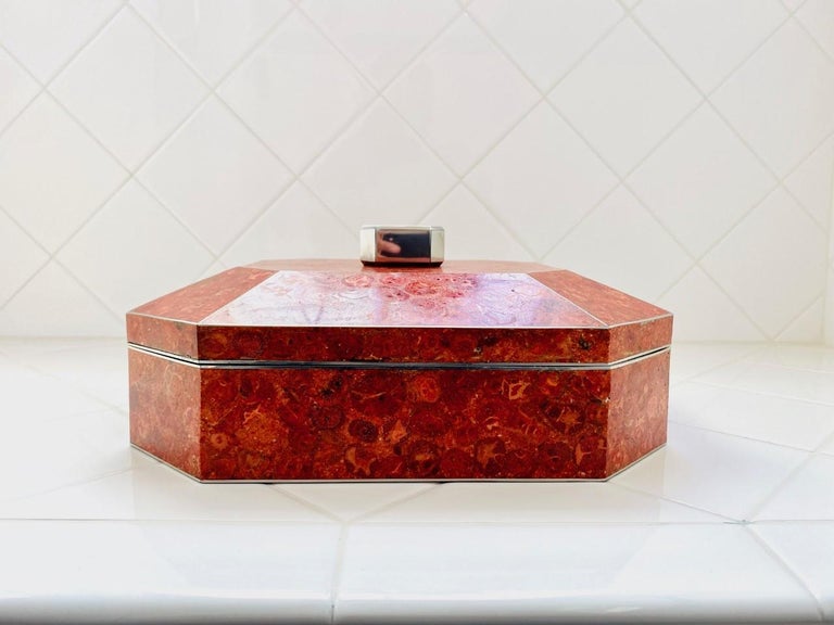 Luxurious red coral box from Maitland-Smith. This beautiful box crafted of authentic red coral tiles is luxurious and glamorous. Each of the pieces that compiles this box has its natural markings that complement the overall piece. This box dates to