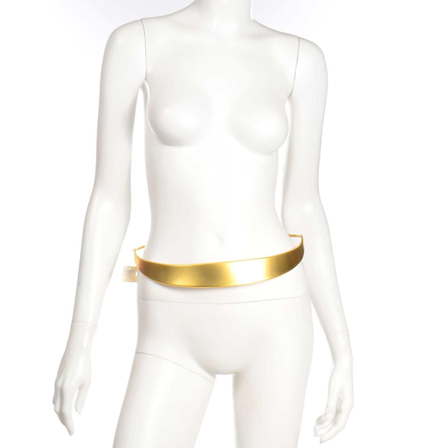 This is a rare, deadstock Robert Lee Morris for Donna Karan gold plated half moon waist belt. Robert Lee Morris Donna Karan pieces have such a rich, refined look, and we grab them whenever we can!There is a chain that wraps around the back of the