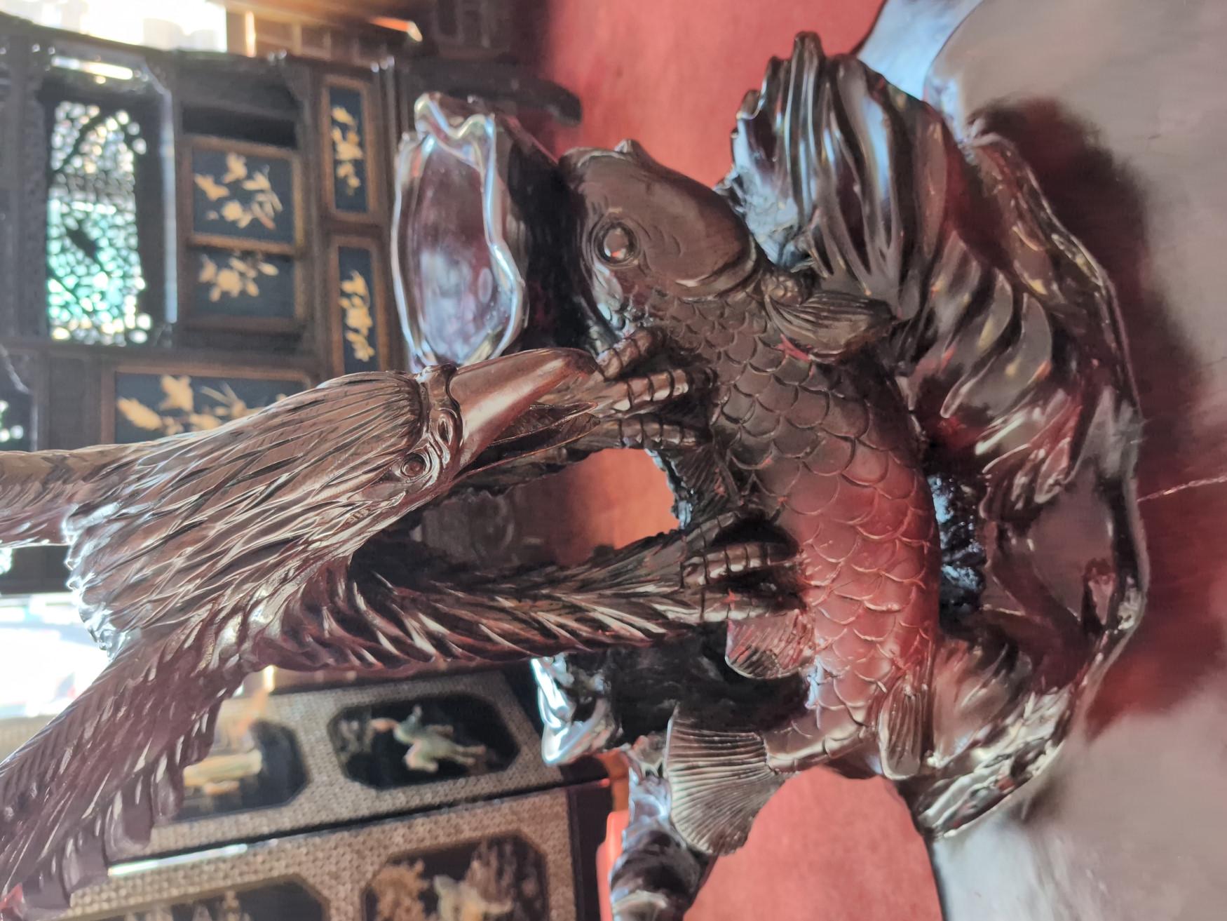 Quelle belle trouvaille ! On ne voit pas ça partout ! Bois de rose massif, la table comporte un magnifique aigle sculpté tenant un poisson koi dans ses serres, une petite surface plate à côté de la sculpture pour exposer une plante ou tout autre