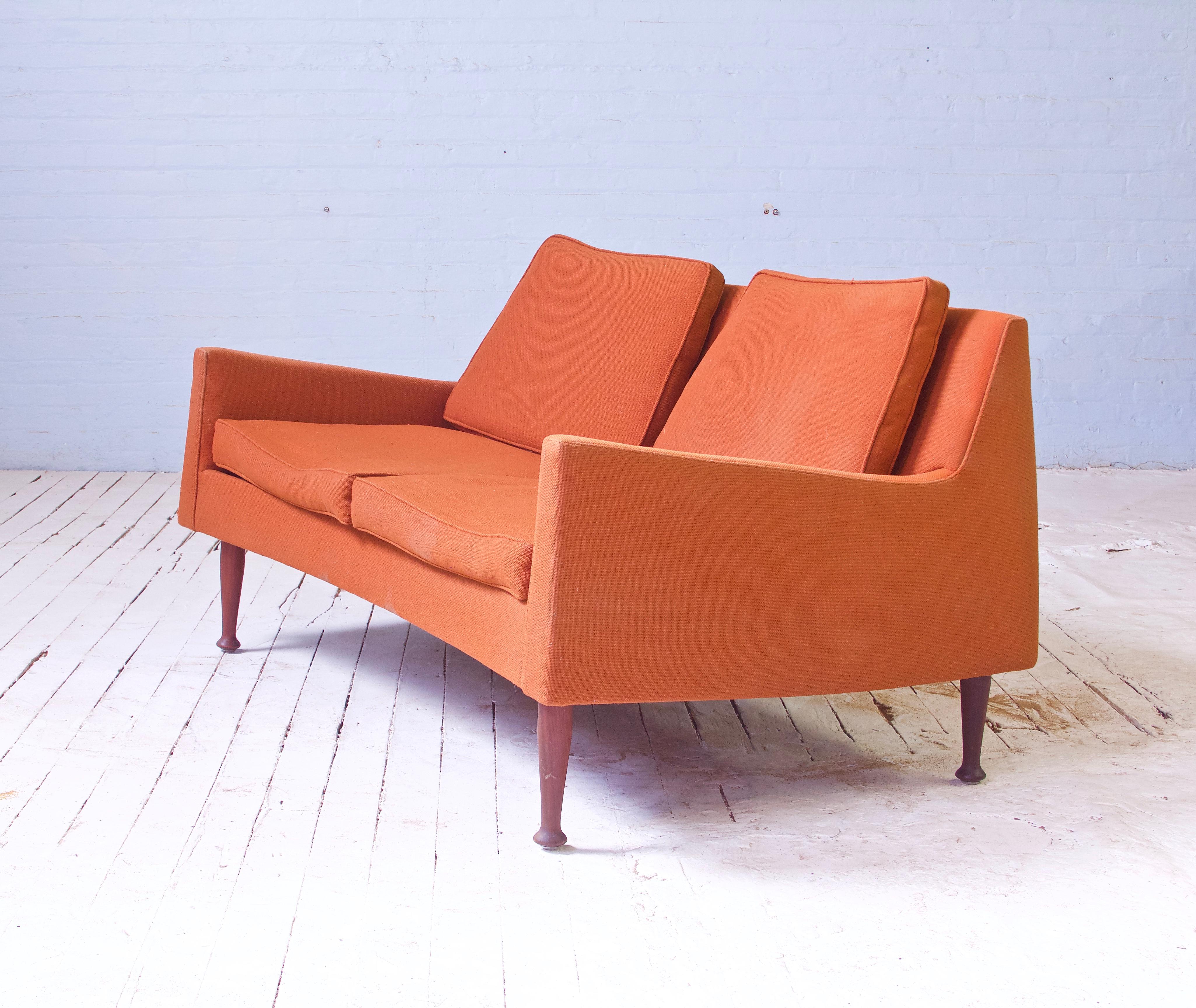 A rare and early two seater sofa or settee by Jens Risom for Risom Manufacturing Corp. in walnut & original nubby wool upholstery with hand-stitching. Completely original vintage condition, manufacturer's tag and designer's cloth tag both remain