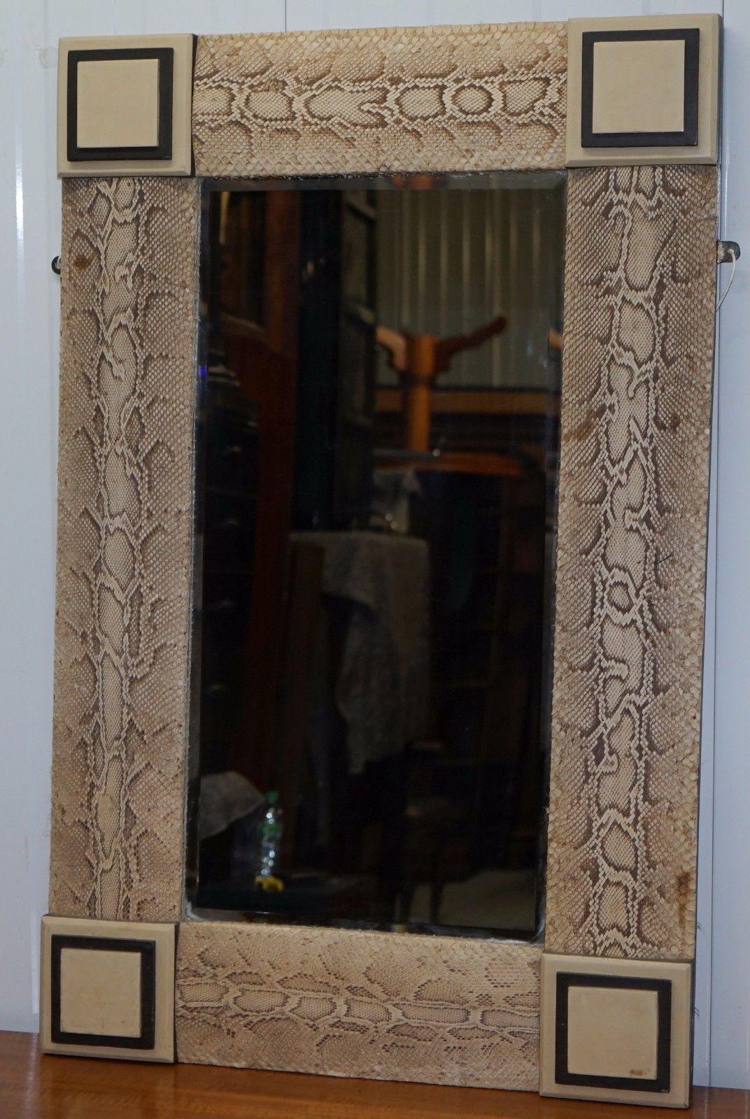 Nous sommes ravis d'offrir à la vente ce charmant miroir ancien encadré en bois et recouvert de peau de serpent, fait à la main.

Il m'a été vendu comme ayant été acheté chez Versace, mais en l'absence de leur label, je ne le mentionne pas en tant