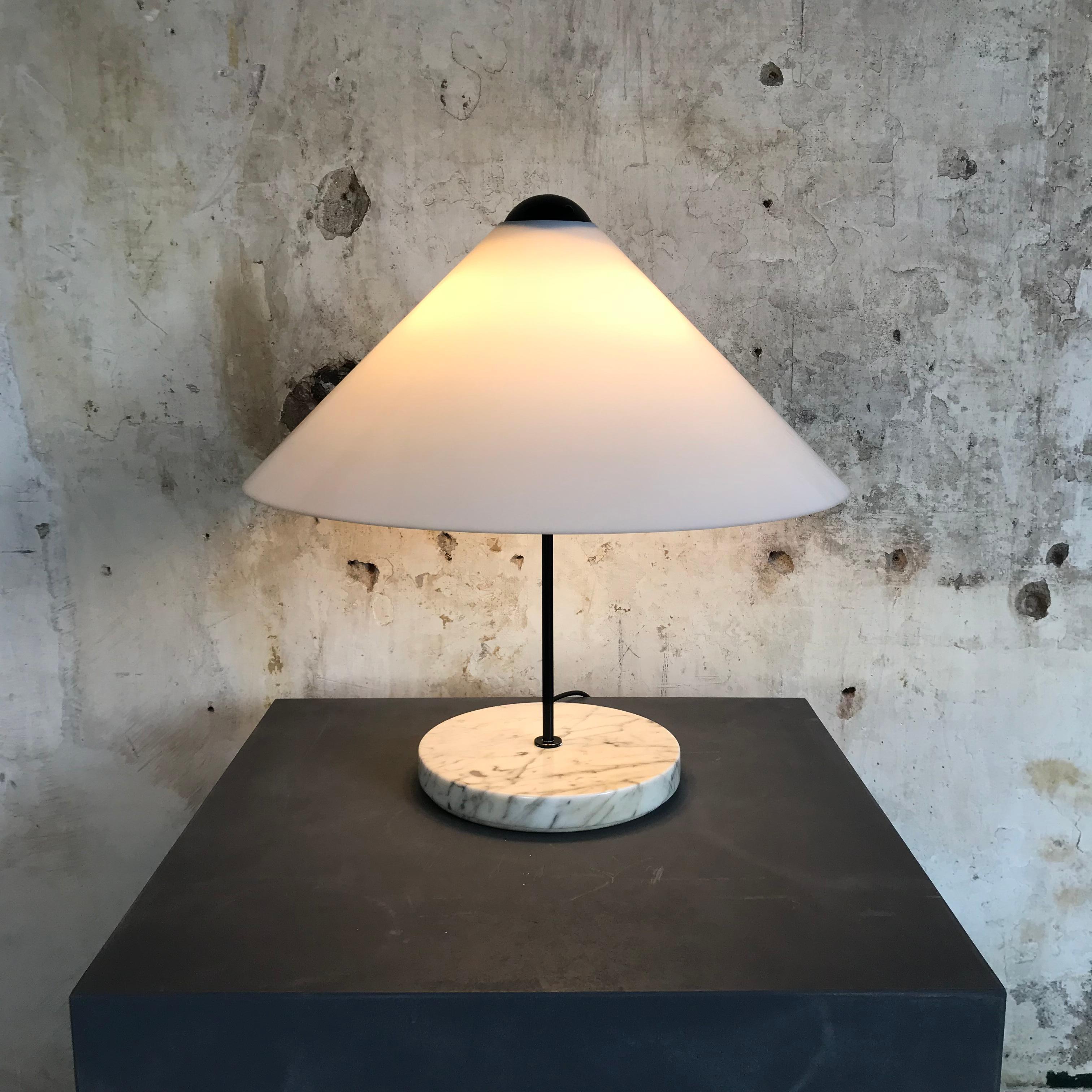 This deceptively simplistic lamp is from the ‘Snow’ series and was only in production for a very short period. This lamp has an opaque white Perspex acrylic shade which is suspended from a blackened metal orb. It has two light sockets (E27) and a