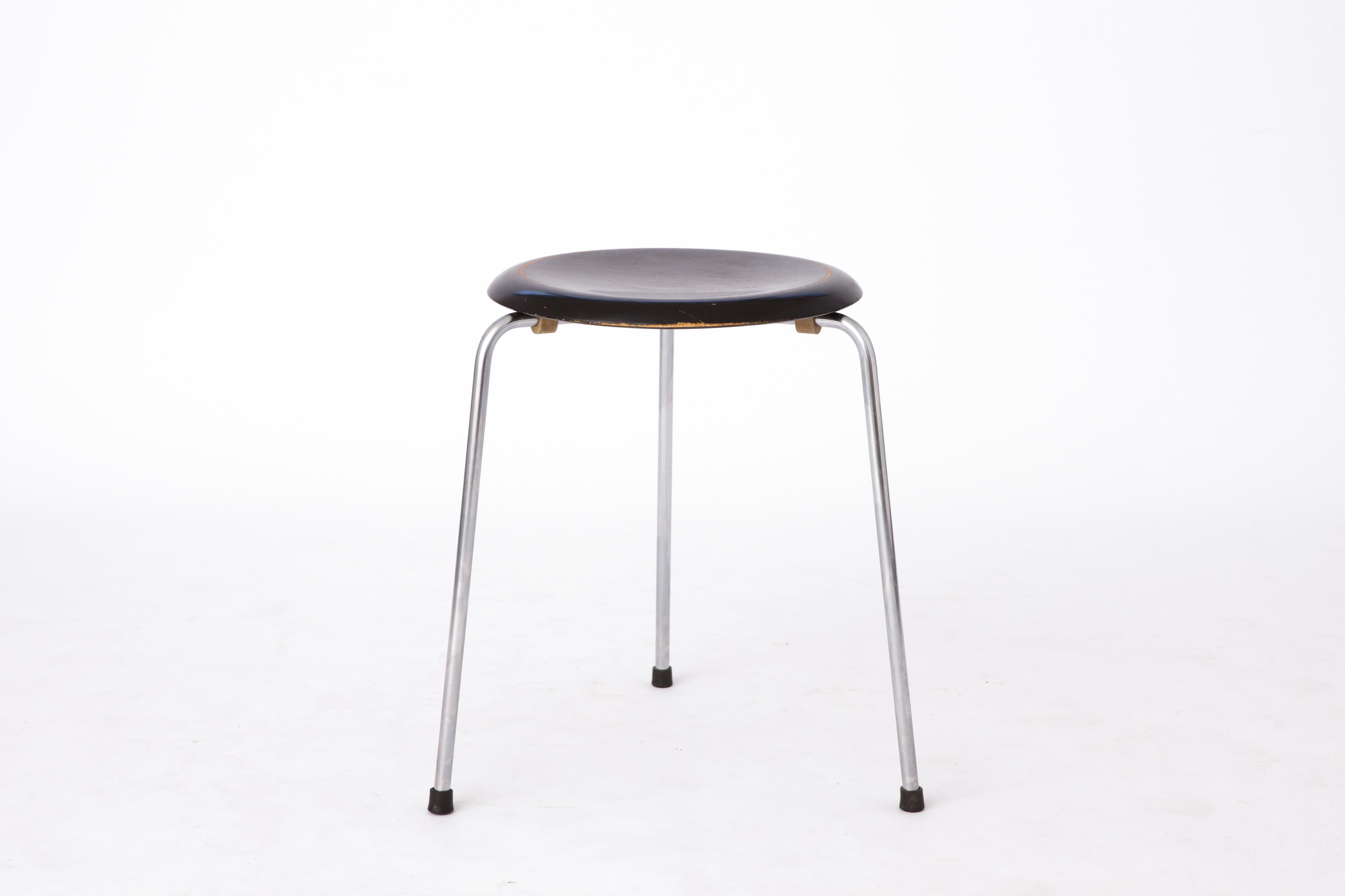 The stool DOT was designed by Arne Jacobsen in the 1950s at the same time as the Ant Chair or the Ant and manufactured by Fritz Hansen. Officially, it came out in 1954 as an originally three-legged stool in veneer. From 1970 the Dot was relaunched