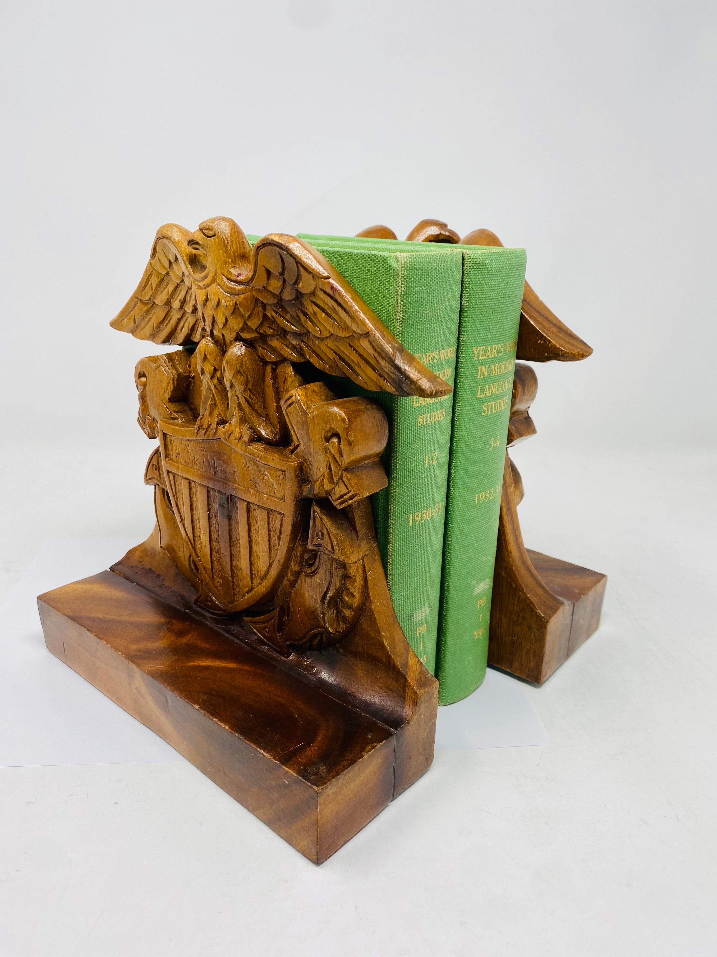 Schönes Paar holzgefertigter Adler-Buchstützen mit gespreizten Flügeln im Stil von Virginia Metalcrafters. Der Adler ist mit ausgebreiteten Flügeln auf einem Wappen dargestellt.  Das Motiv des Adlers in der Dekoration und in der Volkskunst ist in