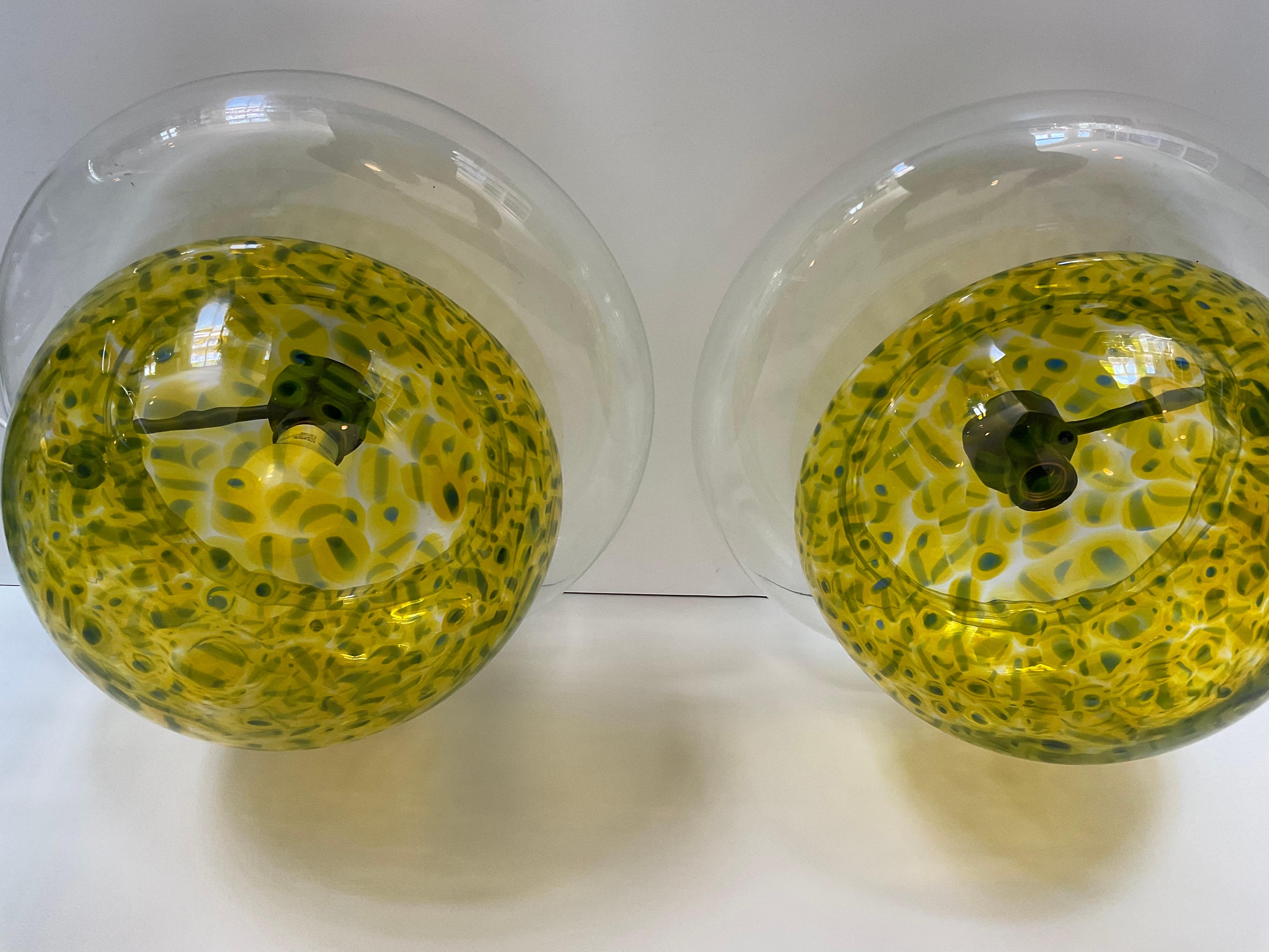 Rare Pair of Vistosi Poveglia Murrine table lamps in vibrant yellow. These lamps were designed by Gae Aulenti and are seldom seen on the open market. Finding a pair is virtually impossible. These lamps are new old stock and have been in storage