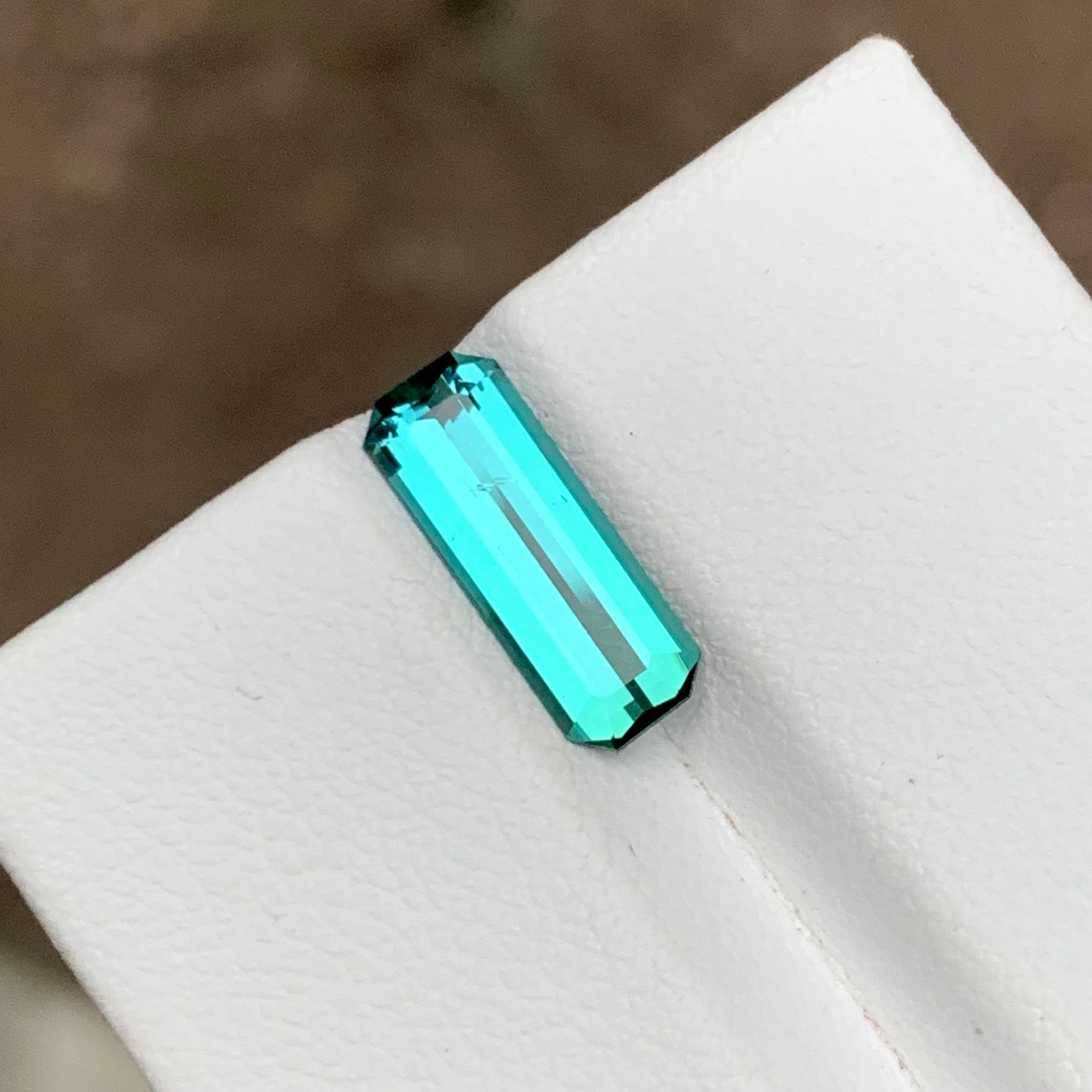 GEMSTONE TYPE: Tourmaline
PIECE(S): 1
WEIGHT: 1.75 Carat
SHAPE: Emerald
SIZE (MM): 12.93 x 4.80 x 3.24
COLOR: Vivid Neon Blue
CLARITY: Approx 95% Eye Clean
TREATMENT: None
ORIGIN: Afghanistan
CERTIFICATE: On demand

Introducing a rare and exquisite
