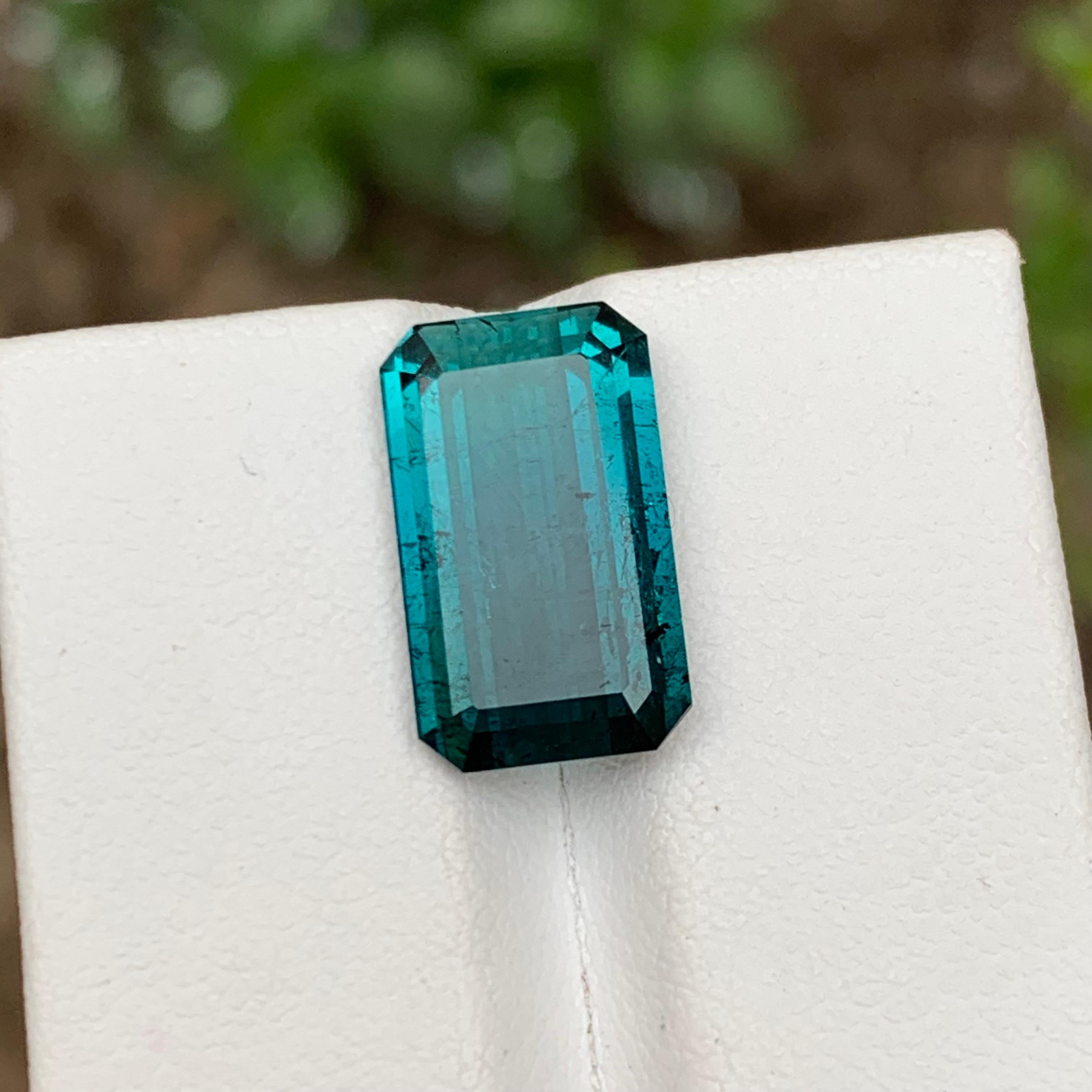 GEMSTONE TYPE: Tourmaline
PIECE(S): 1
WEIGHT: 6.60 Carats
SHAPE: Emerald Cut
SIZE (MM): 15.30 x 9.13 x 4.87
COLOR: Vivid Neon Blue
CLARITY: Moderately Included 
TREATMENT: None
ORIGIN: Afghanistan
CERTIFICATE: On demand

Introducing our exquisite