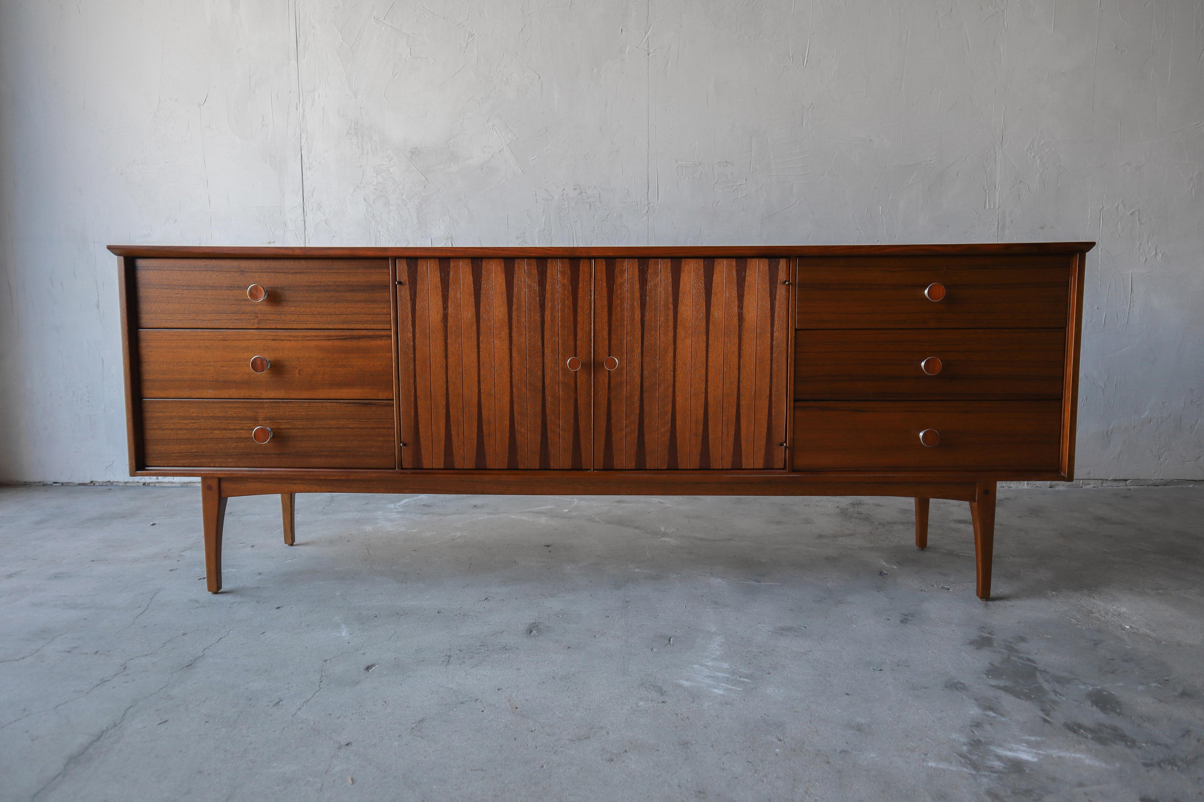 Super rare and early midcentury, 6 drawer dresser by Lane. The dresser is absolutely beautiful. It's a stunning combination of walnut and rosewood with brass pulls that too are inlaid with rosewood. This dresser is beautiful enough to be used in a