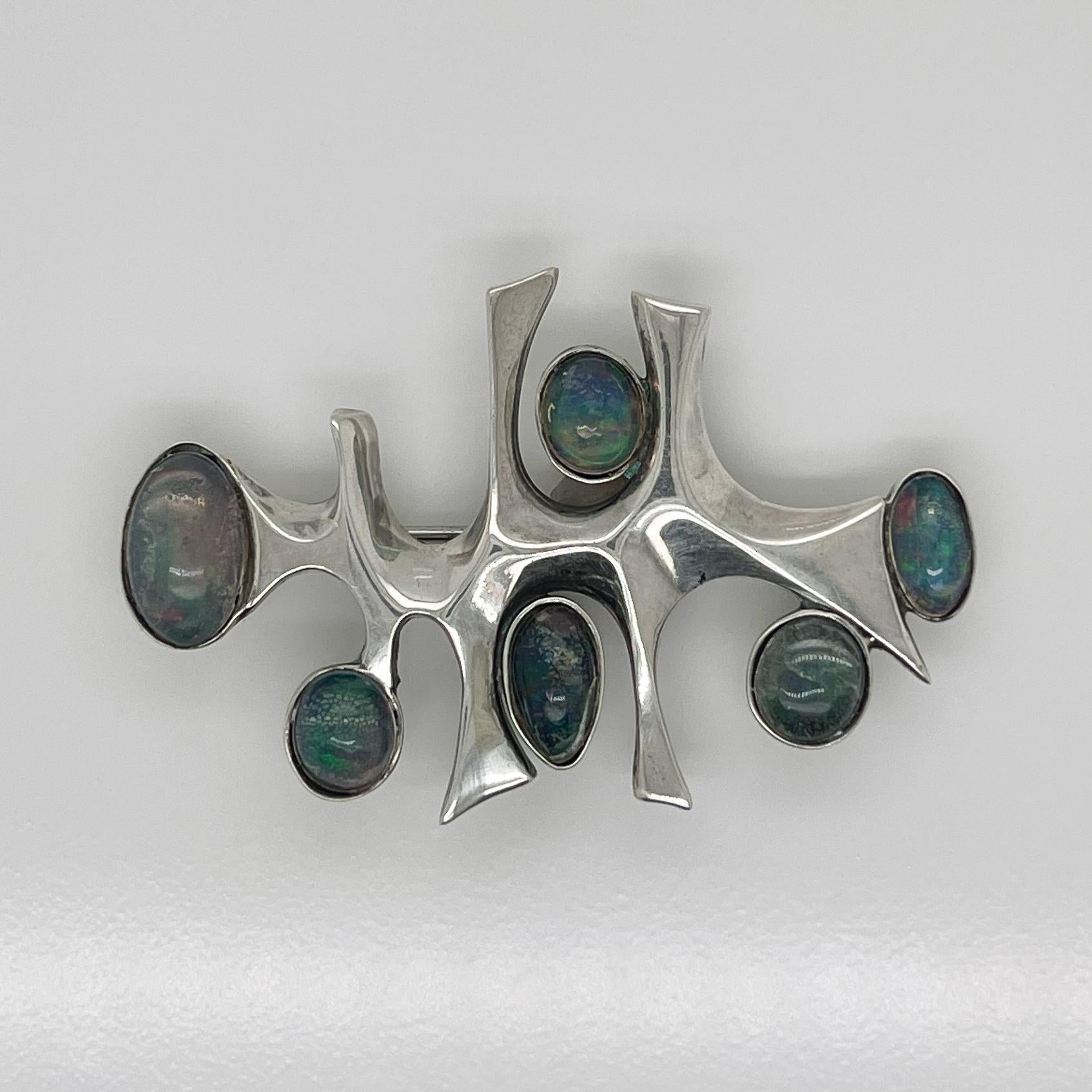 A very fine Wesley Emmons modernist space age brooch with opal cabochons.

Emmons was an important jewelry maker in Philadelphia during the mid-20th century. He created cutting-edge jewelry for decades, and his long client list included numerous