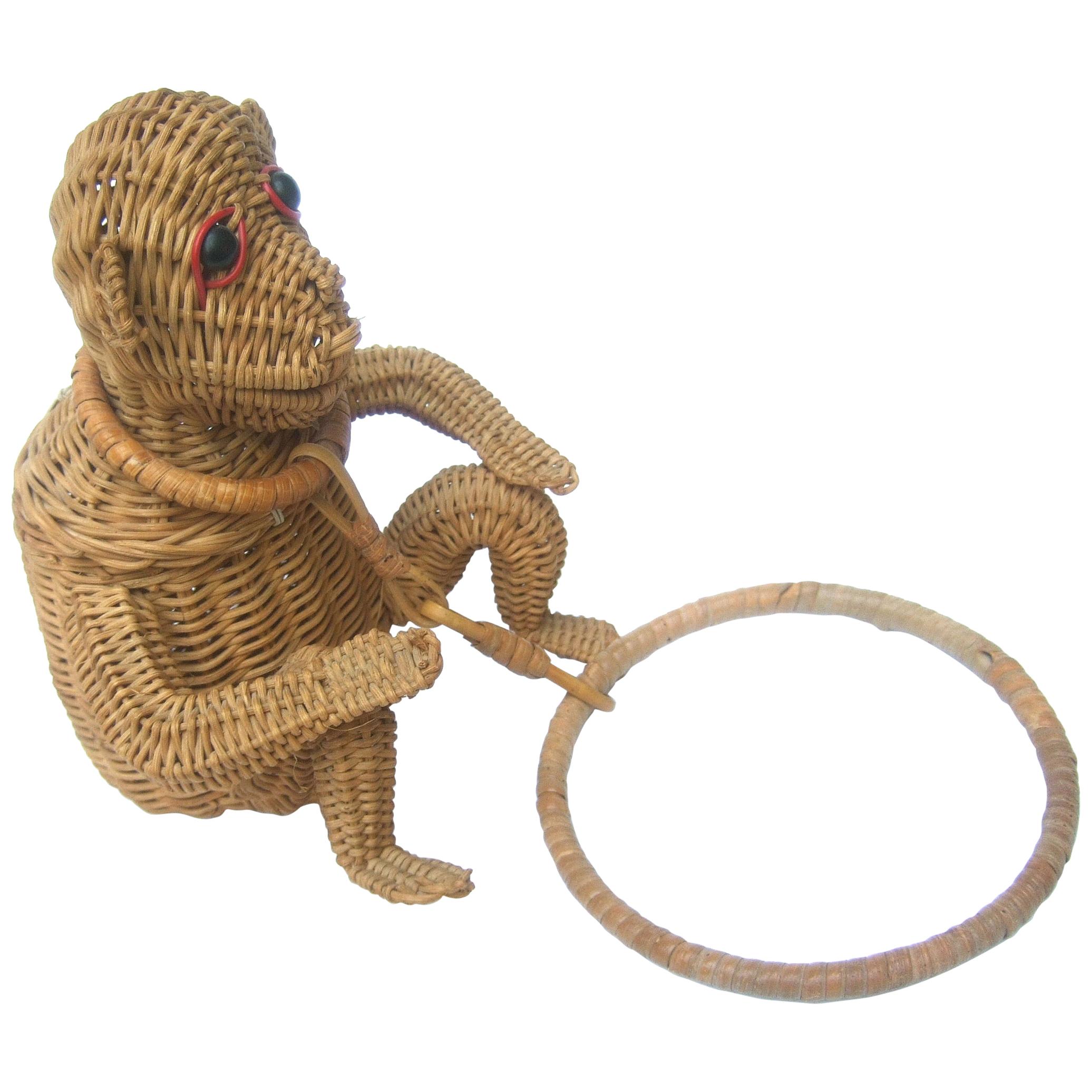 Rare whimsical wicker rattan monkey handbag c 1950s 
The charming diminutive artisan monkey handbag  
is constructed with woven wicker bands

His face is adorned with black resin button eyes
The endearing monkey is suspended from a circular 
round