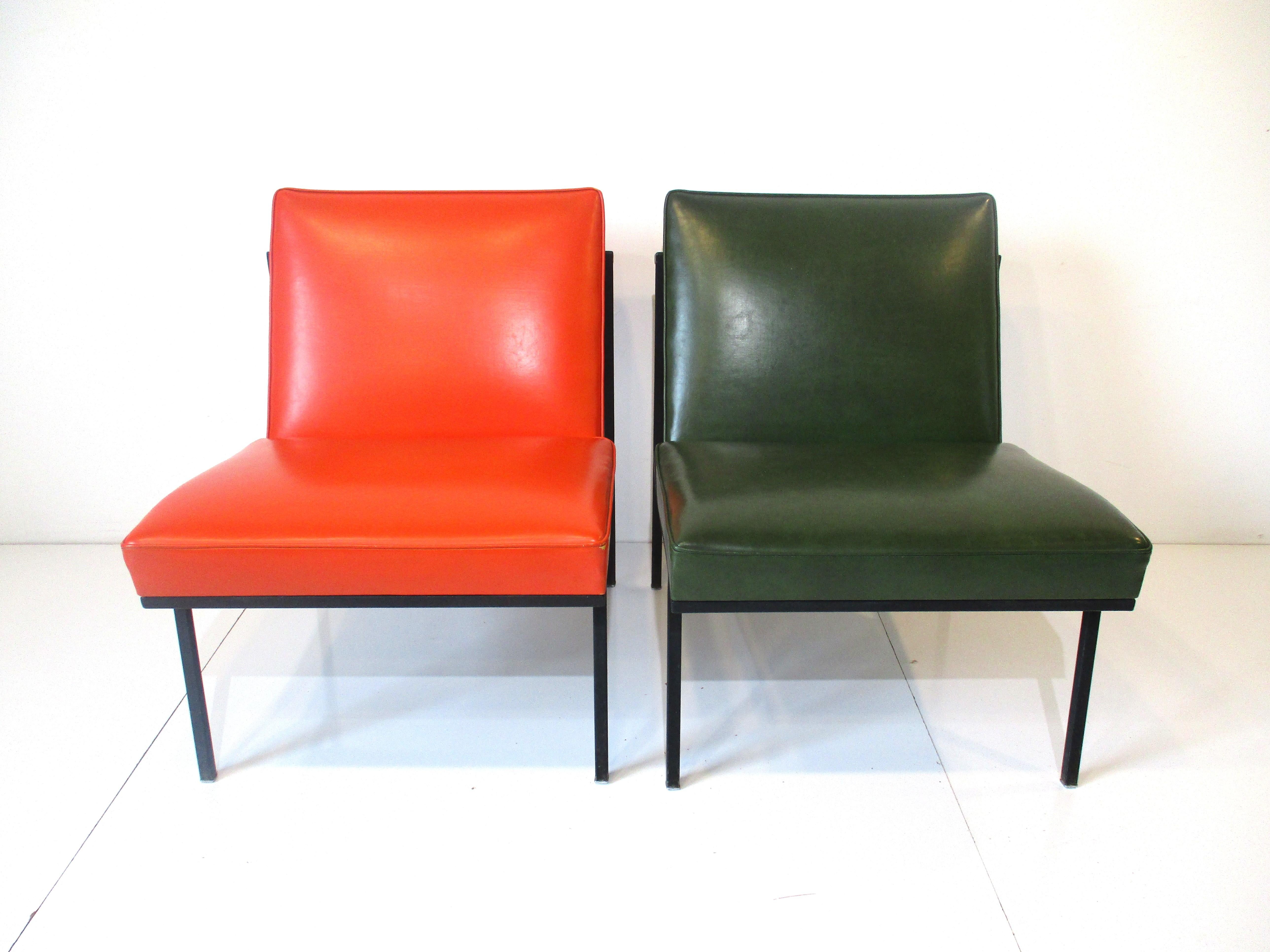 A pair of rare lounge chairs designed by William Armbruster with satin black welded steel frames , chrome leg tips and Naugahyde upholstered cushions . The frames are well designed with canvas back supporting straps with a artistic and architectural