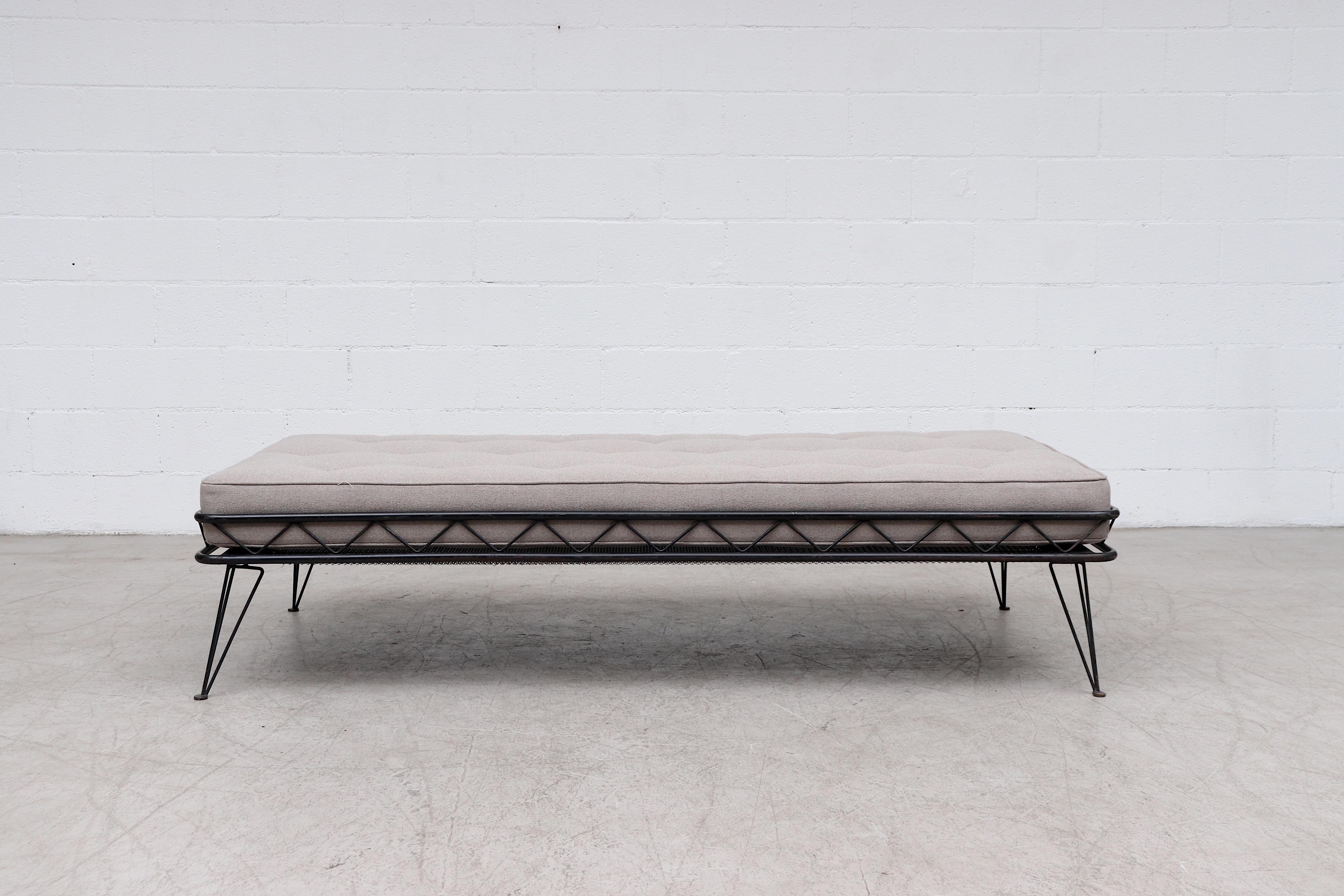 Rare Wim Rietveld Arielle daybed for Auping, 1953. Architectural black enameled metal frame with newly made tufted grey mattress. Frame in original condition with lovely patina and original Auping name on the mesh screen. Wear is consistent with its