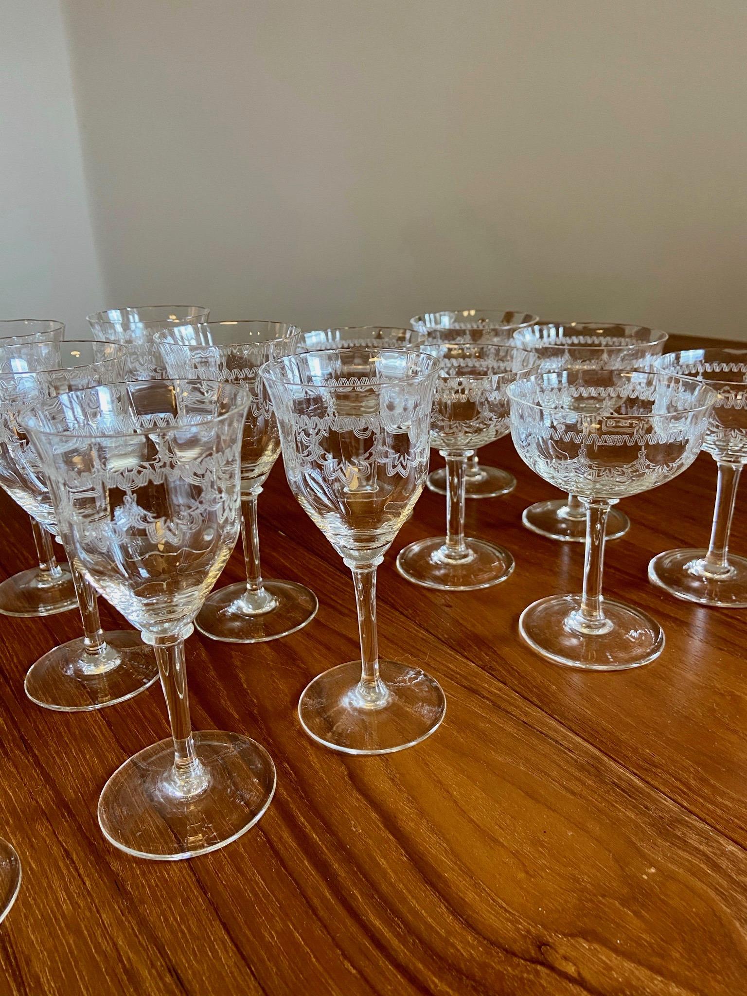 Rare wine and champagne crystal glasses from circa 1900-1920. Handmade, mouth-blown and hand cut crystal with an elegant etched motif. As they are hand made, there can be very small irregularities in the shape and weight. 
In this set you will find