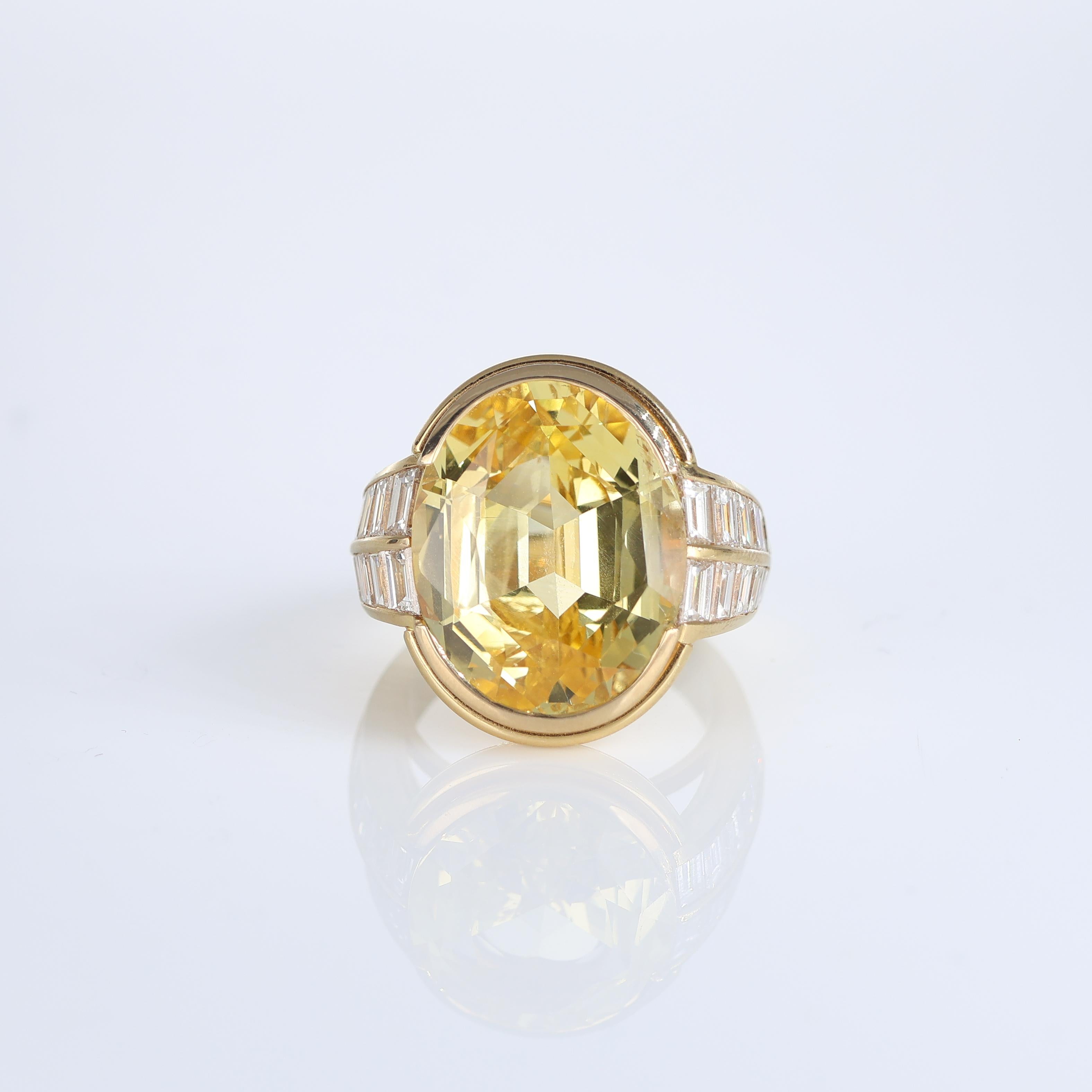 An extraordinary 18K yellow gold ring featuring a rare, untreated 17-carat oval yellow sapphire of exceptional brilliance and beauty. The sapphire’s natural golden hue is perfectly complemented by the elegant side diamonds, set in baguette cuts,