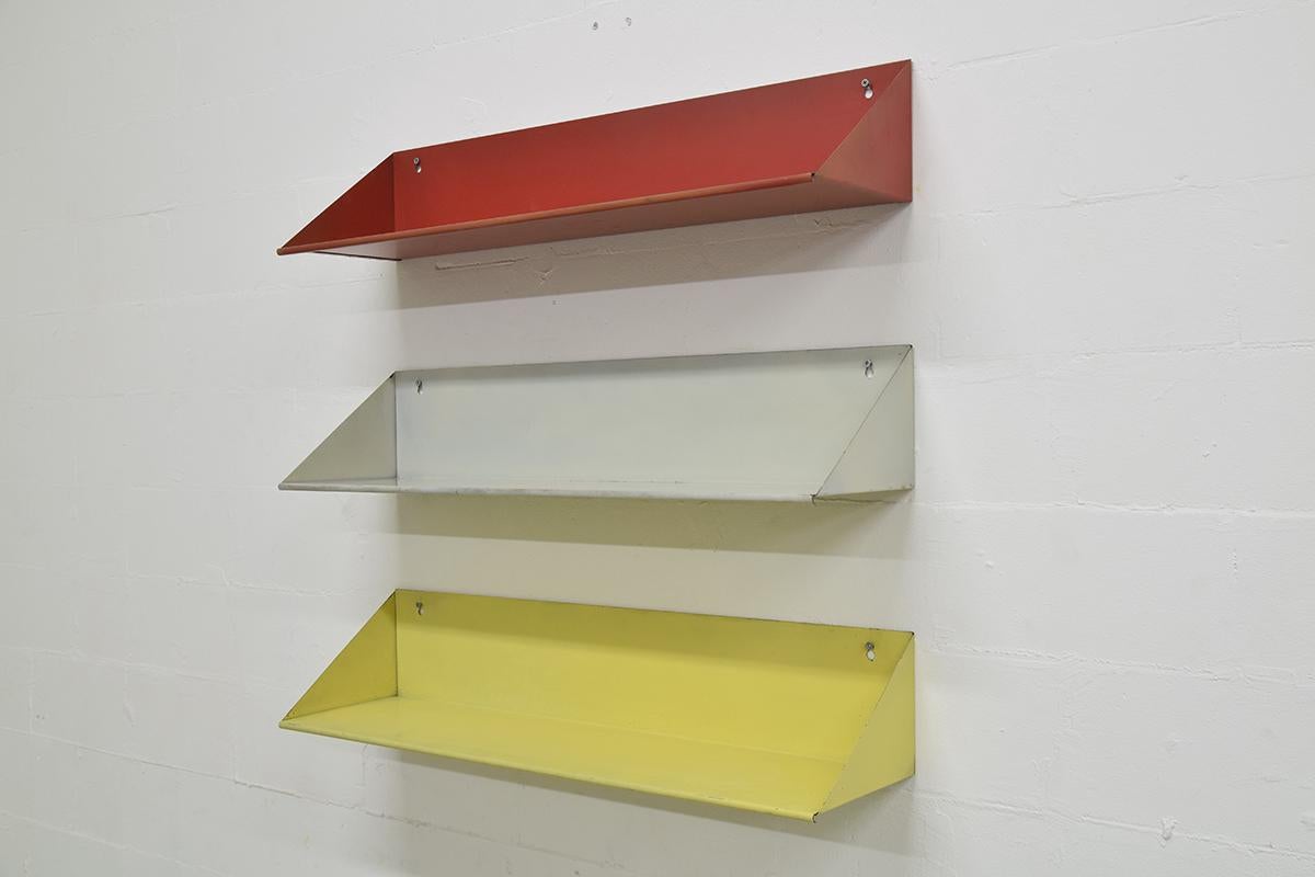 Very rare Minimalistic set of three colored metal wall shelves. Designed by the famous Dutch artist, designer and architect Constant Nieuwenhuys. Also one of the members from the Cobra Art group. These red, yellow and grey shelves were designed for